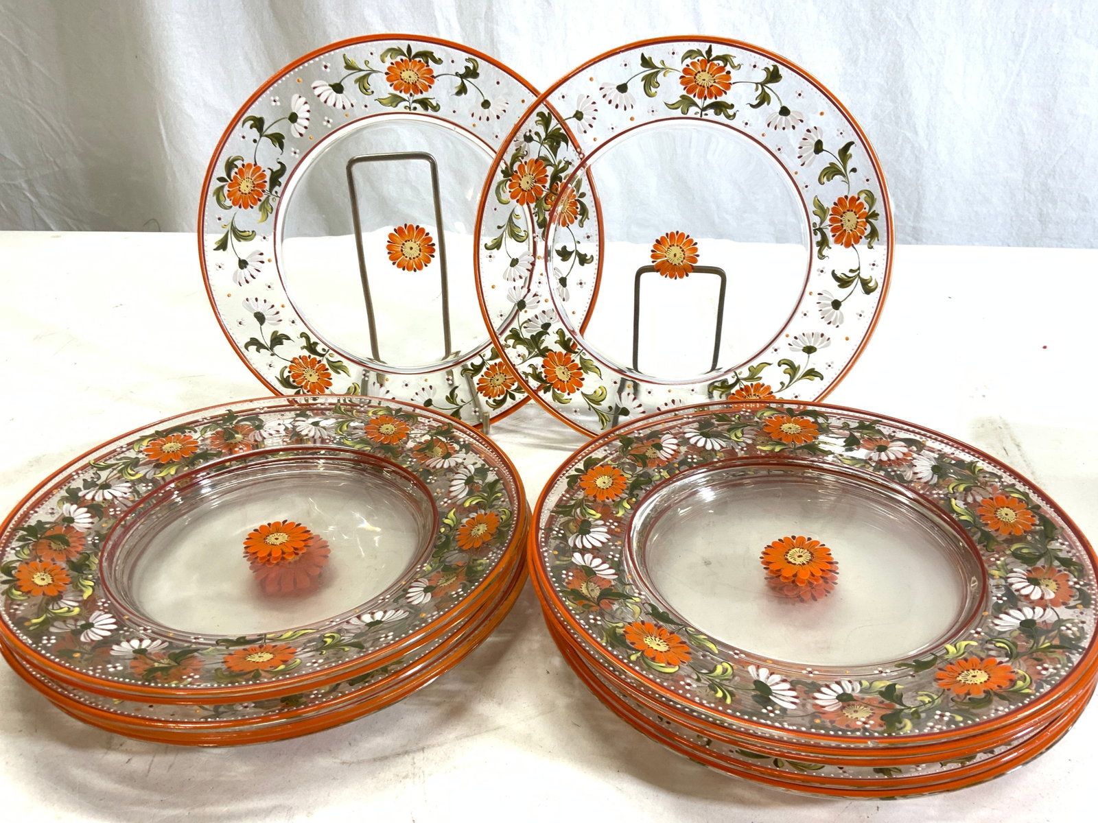Set 11 Mid Century Hand Painted Glass Plates: Clear glass plates that hare hand painted with 1960s style orange and yellow flowers with green stems. Plates measure 8.5 in. Chipping observed. -3