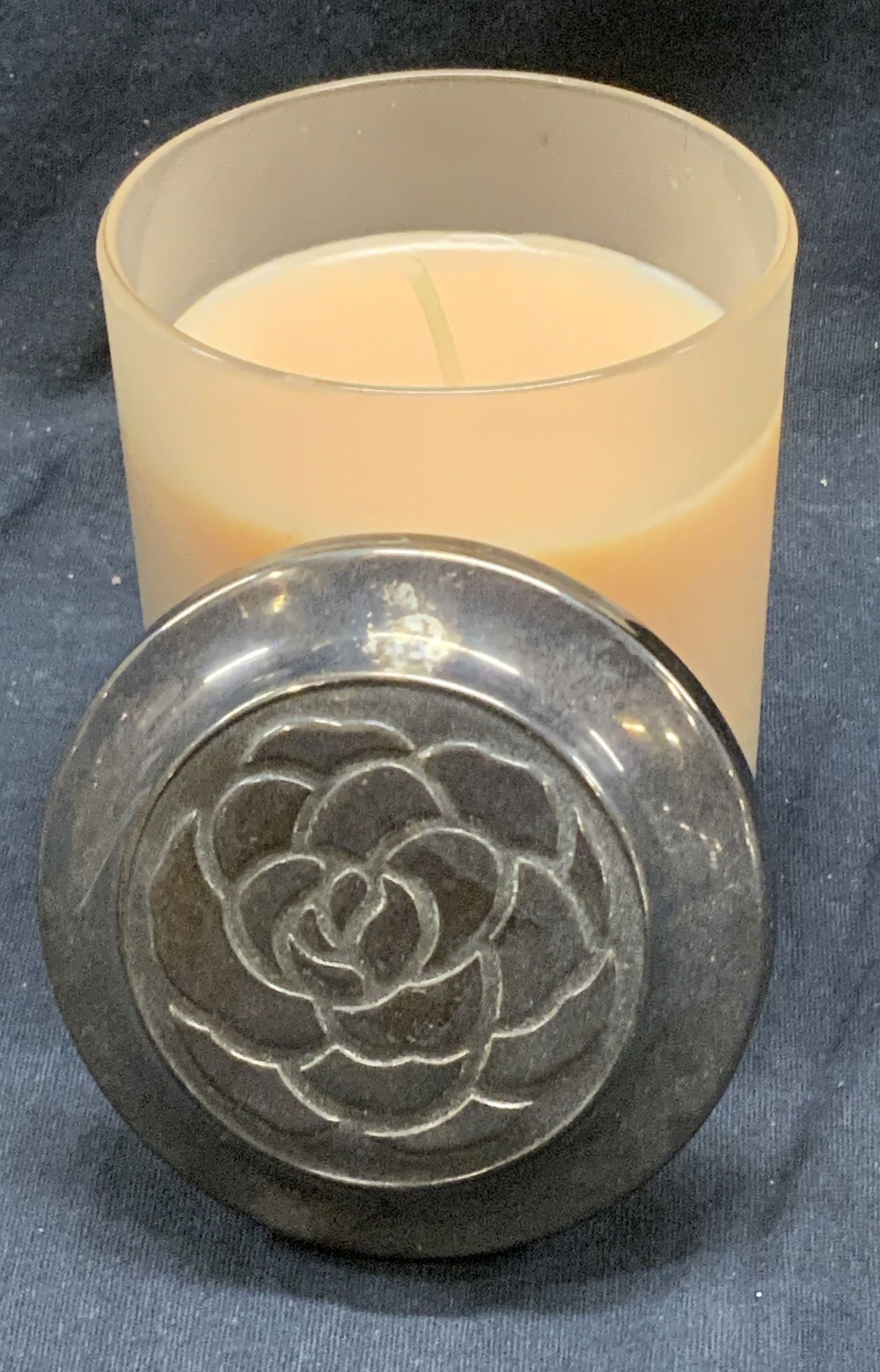 CHRISTOFLE Petales Fragrance Candle, France Italy: Luxury CHRISTOFLE candle in a frosted glass jar with silver plate lid with a rose design, signed CHRISTOFLE. New candle. Petales, peach toned candle with rose fragrance. Bottle is made in Italy and ma