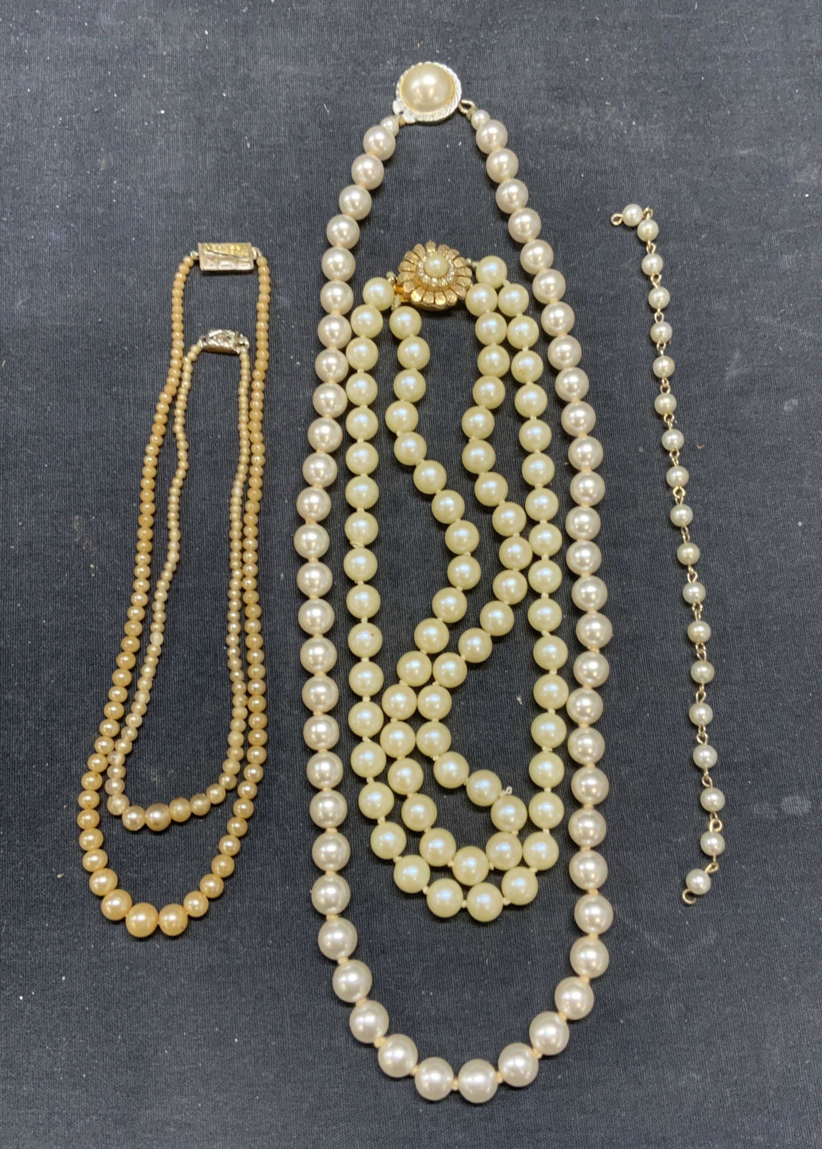 Lot 5 Vintage Faux Pearl Necklaces +: Lot of 5 vintage jewelry pieces. 4 faux pearl beaded necklaces and 1 faux pearl beaded bracelet. Longest piece drop length approx. 11 inches. Some surface wear including scratching observed to all pie
