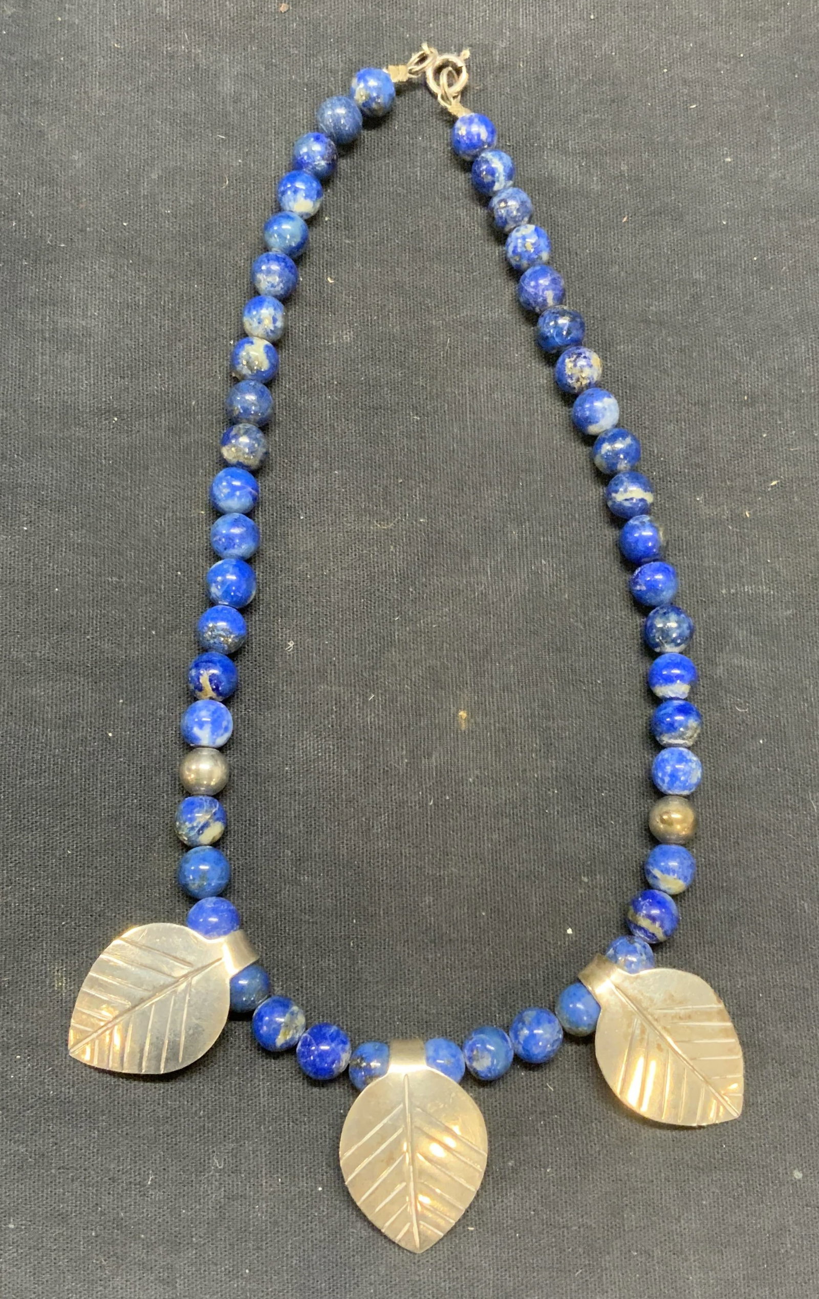 Vintage Lapis Beaded Sterling Silver Necklace: Vintage lapis lazuli beaded necklace with sterling silver leaf pendants. Marked 925, Taxco on pendants. Drop length approx. 7 inches. Total weight 59.4 grams. Some surface wear including scratching ob