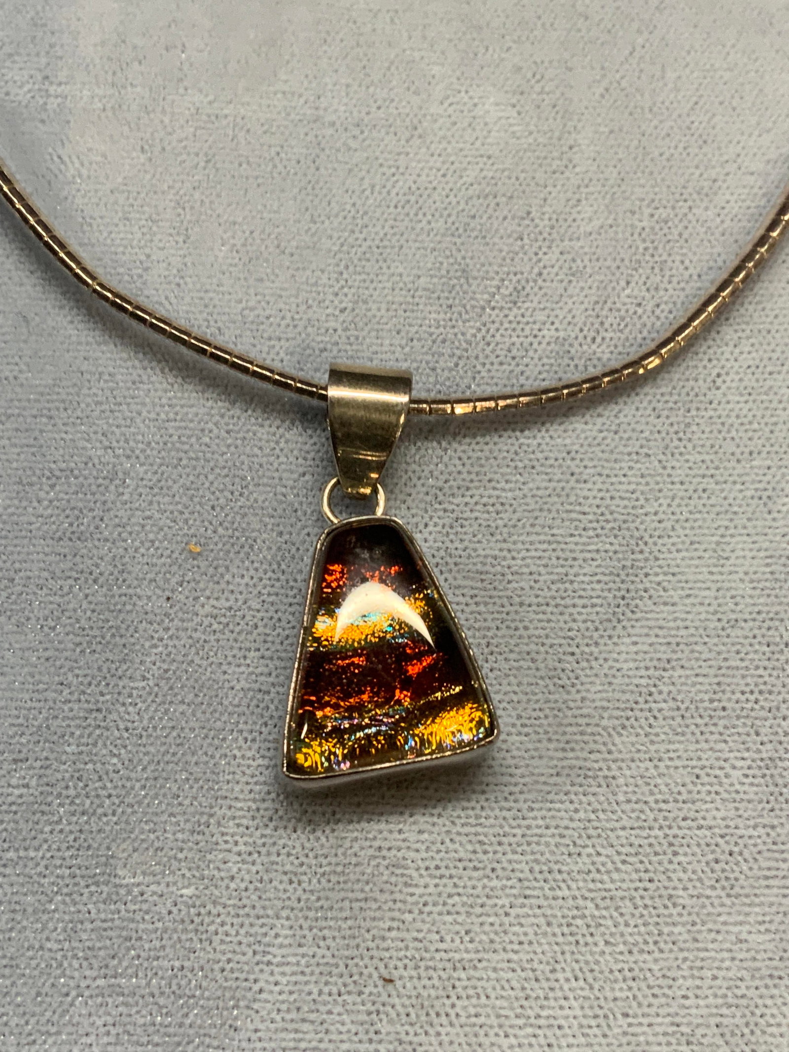 Sterling Silver Glass Pendant Necklace: Sterling silver necklace with sterling silver orange and yellow toned glass pendant. Marked 925 on clasp and pendant. Drop length approx. 6.5 inches. Total weight 16.3 grams. Some surface wear includi