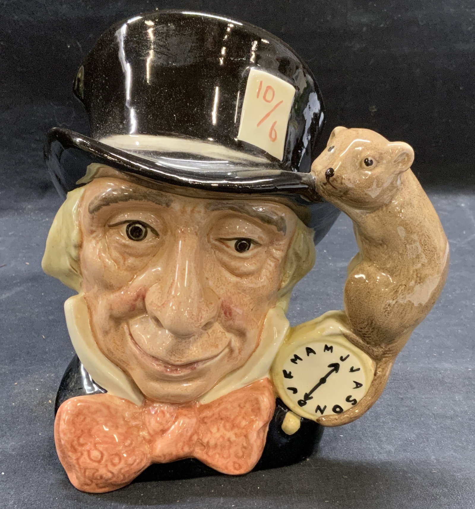 Vtg Royal DOULTON Mad Hatter Toby Jug England: Vintage 1970 Royal DOULTON ceramic Mad Hatter Toby jug. Figural and otter motif. Trademarked to underside. Made in England. Measures approx. 6.5 x 5 x 8 inches. Some surface wear including scratching 