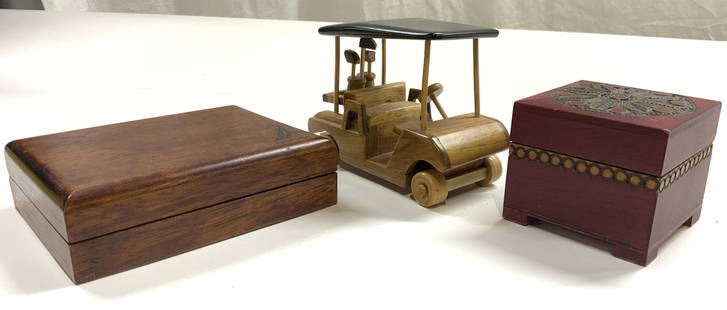 Lot 3 Wood Lidded Trinket Boxes & Golf Cart Figure: Lot includes 1 wooden golf cart figure, 1 red toned carved wooden trinket box with lid and 1 brown toned wooden lidded box trademark NAUTICA. Smaller box is footed and has intricately carved detail to