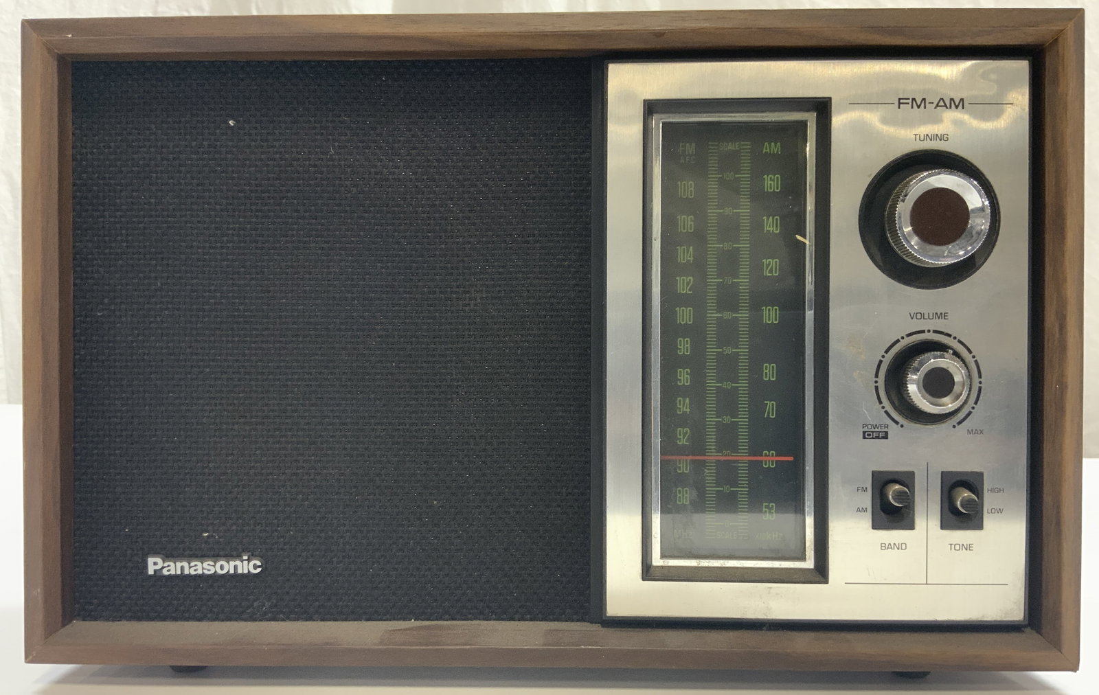 PANASONIC Vntg 1970s Am FM Radio: Radio is trademarked PANASONIC. Piece is vintage circa 1970s. Radio has brown toned wood shell frame. Piece has Tuning & Volume knobs, Band & Tone buttons. Radio measures approximately 12.5 inches wid