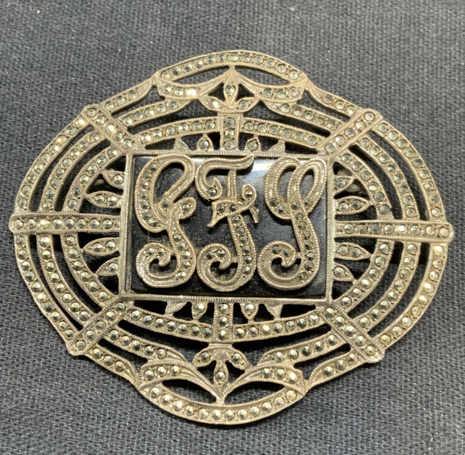 Vintage Sterling Silver & Marcasite Brooch: Vintage sterling silver and marcasite brooch with monogram. Marked sterling to underside. Hinge pin to underside. Measures approx. 1 7/8 x 2.25 inches. Total weight 18.5 grams. Some surface wear inclu
