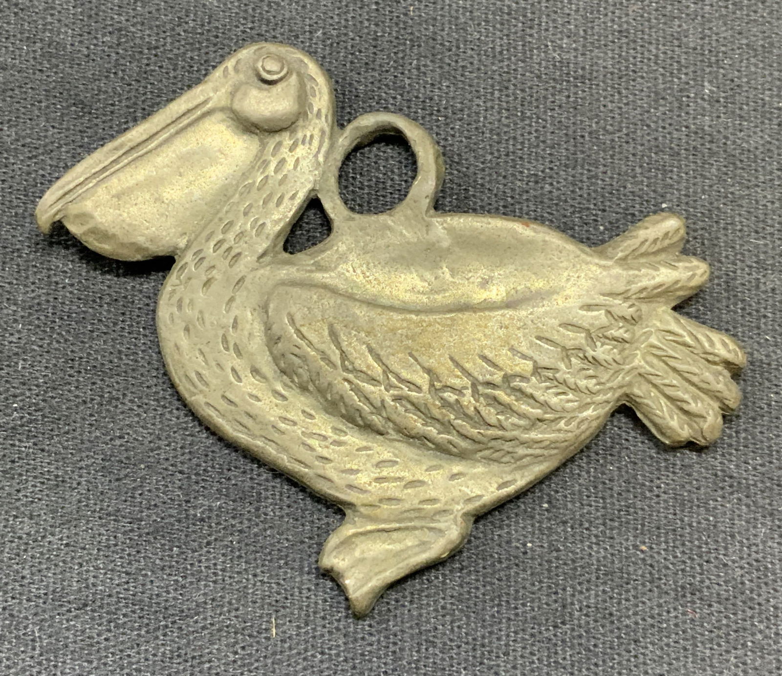 Vintage Seagull Pewter Pelican Pendant, Canada: Vintage Seagull pewter pelican motif pendant. Embossed raised surface. Measures approx. 2 x 2.25 inches. Signed to underside. Made in Canada. Some surface wear including scratching observed. Estate je