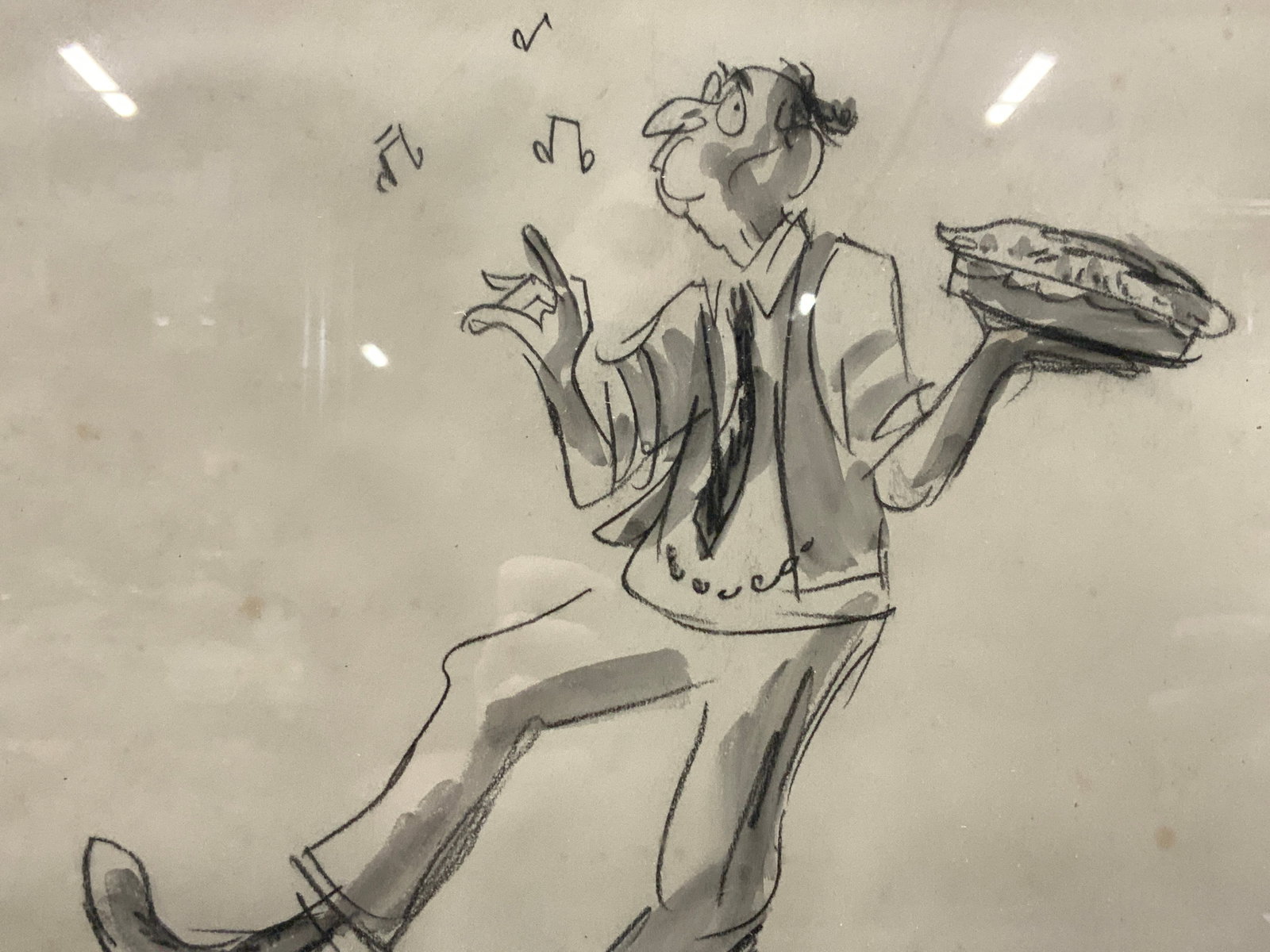 Graphite & Ink Dancing Man Cartoon: A cartoon drawing of a man dancing and whistling with a pie in his hand. Framed in a black wooden frame with purple toned mat boards approx 17 x 19 inches window measures 10 x11 inches Moderate wearin