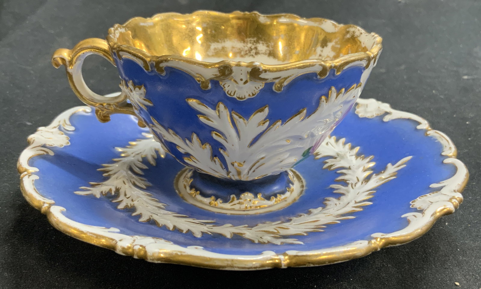MEISSEN Vntg Porcelain Teacup & Saucer: Undersides have double crossed sword Meissen trademark. Lot includes 1 teacup and matching saucer. Each piece has multi toned floral and leaf detail, blue and white tones, & gilt detail. Saucer measur