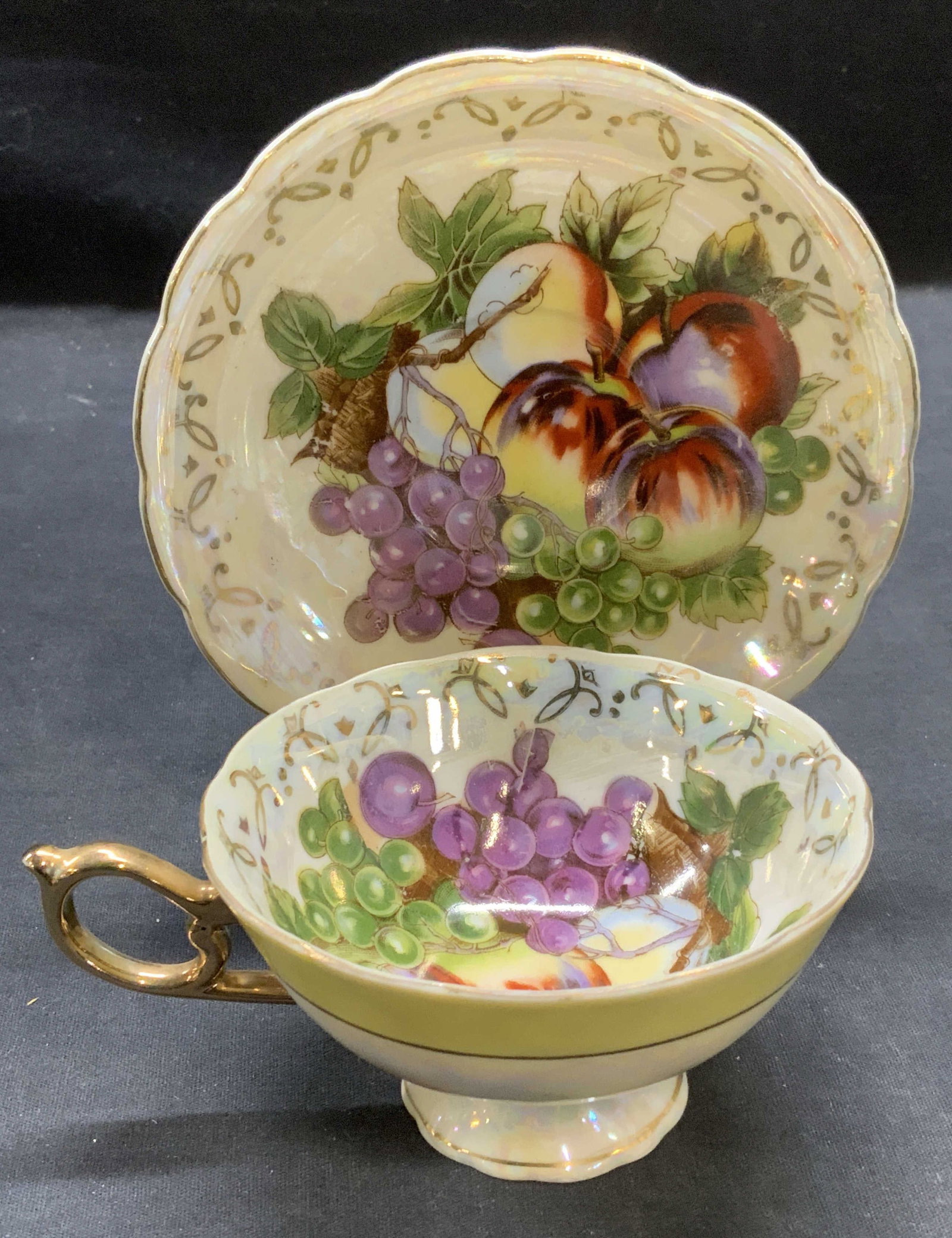 Vintage Lustreware Porcelain Teacup & Saucer: Vintage lustreware porcelain teacup and saucer with silver decoration and hand painted fruit motif. Teacup measures approx. 4 x 2.25 inches. Saucer measures approx. 5.5 inches diameter. Vintage teacup