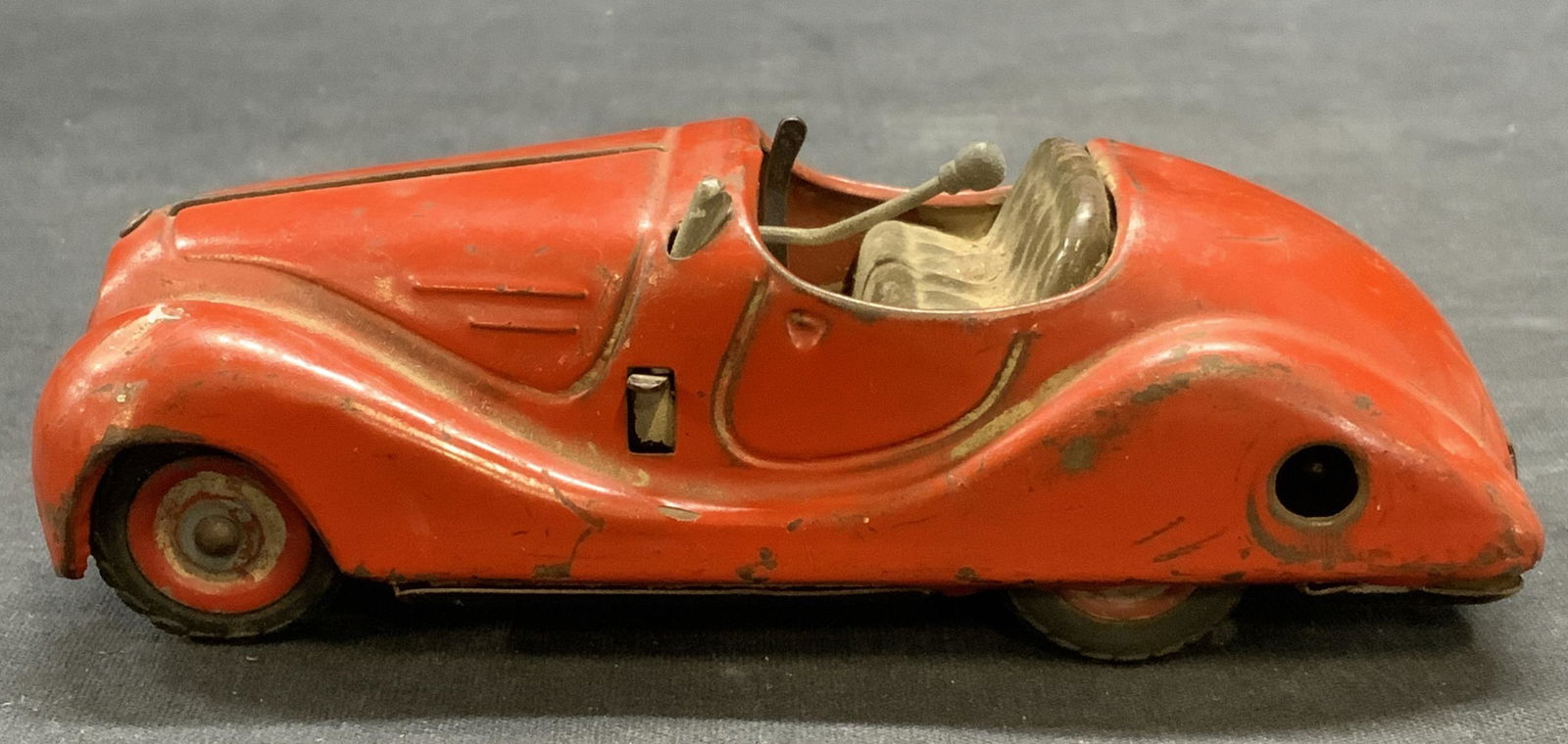 Vtg Schuco Examico 4001 Metal Car Model: Vintage Schuco Examico 4001 enameled red metal car model. Trademarked to underside. Made in Germany. Measures approx. 5.5 x 2.5 x 1.75 inches. Surface wear including scratching and bending observed. S