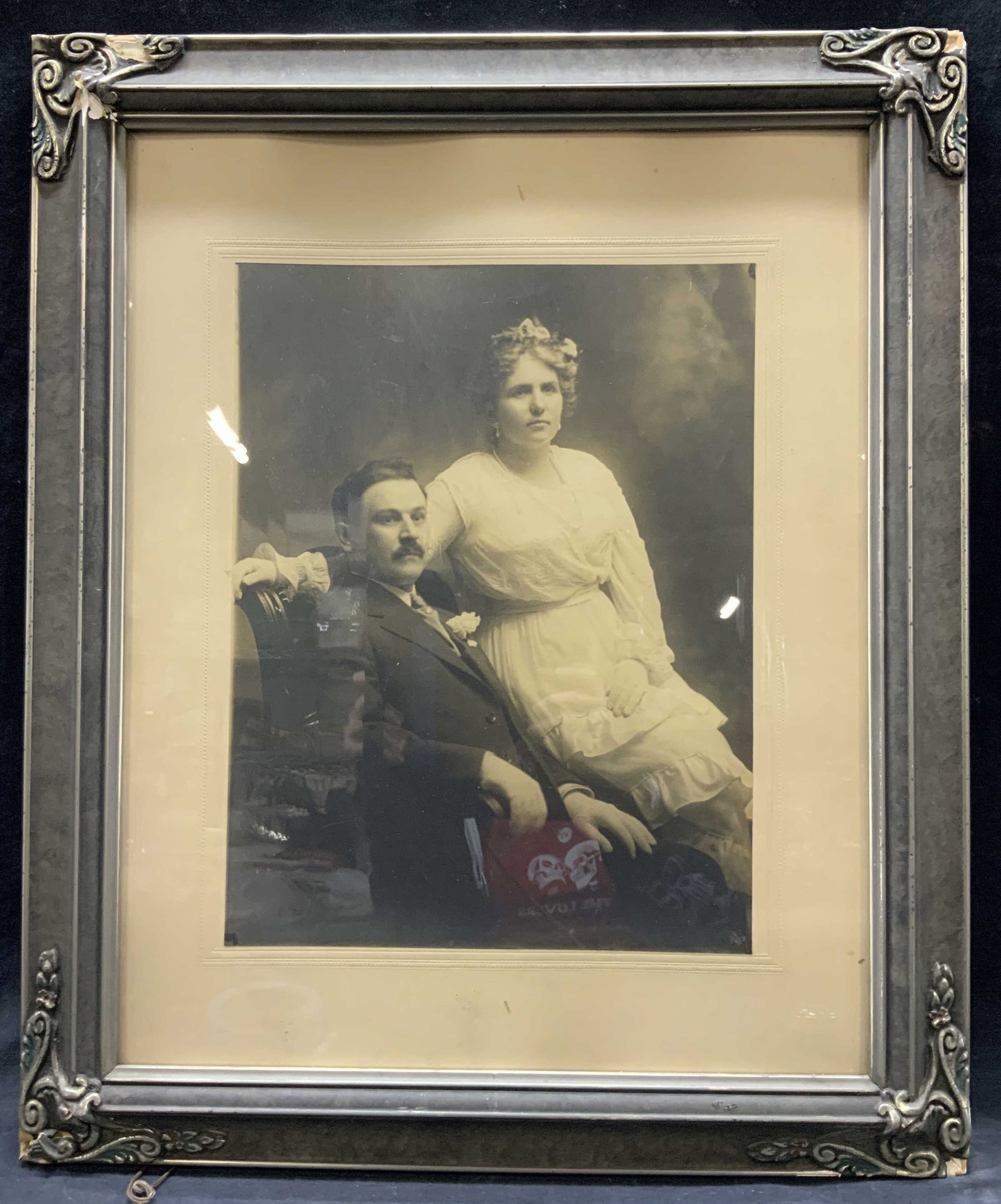 Vtg Black & White Portrait Photograph: Vintage blacks and white photograph of a husband and wife. Framed in an ornately crafted wooden gray toned frame with raised corners and off white backboard. Approx 23 x 19 inches window measures 14 x