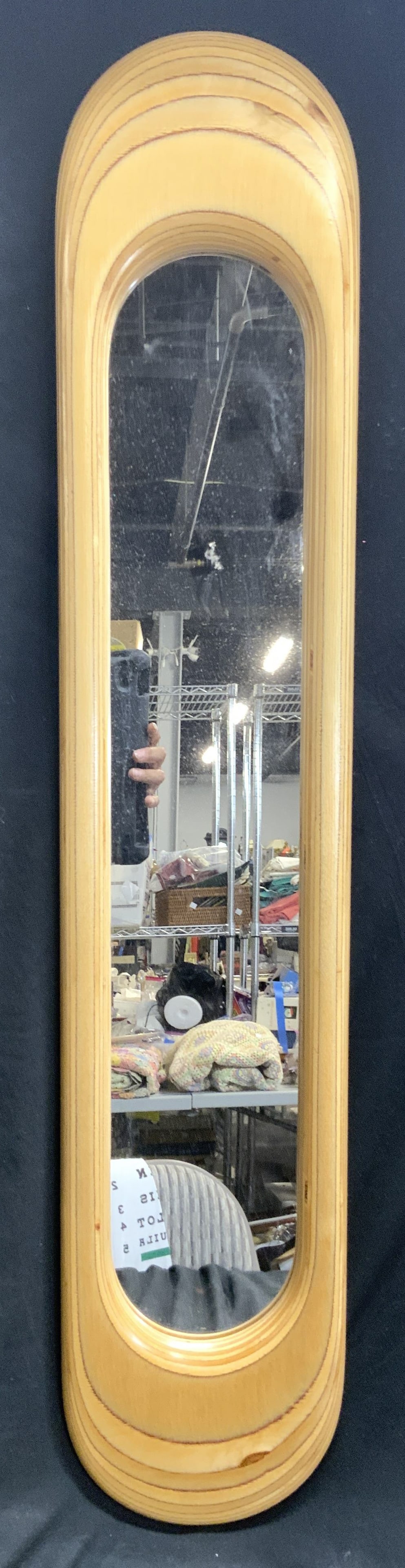 Signed Wood Elongated Oval Wall Mirror: Backside of mirror is signed illegibly. Frame is tan toned, appears to be wooden. Mirror has elongated oval form. Piece measures approximately 36 inches tall 7 inches wide. Mirror, wall mirror, wood f