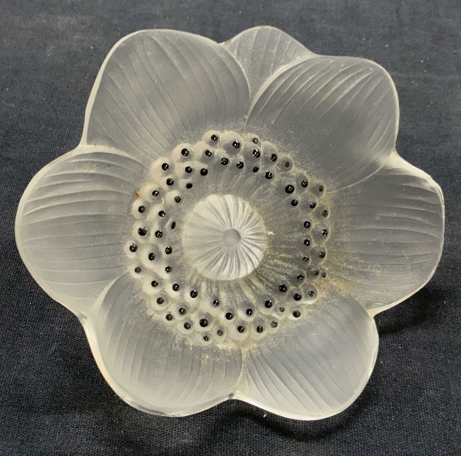 Lalique France Frosted Crystal Flower Figure: A frosted flower figure from Lalique France with raised textures in flower and detailing to petals. Approx 4 inches wide and 2 inches long. Evident cracking to back stem of flower due to age and use L