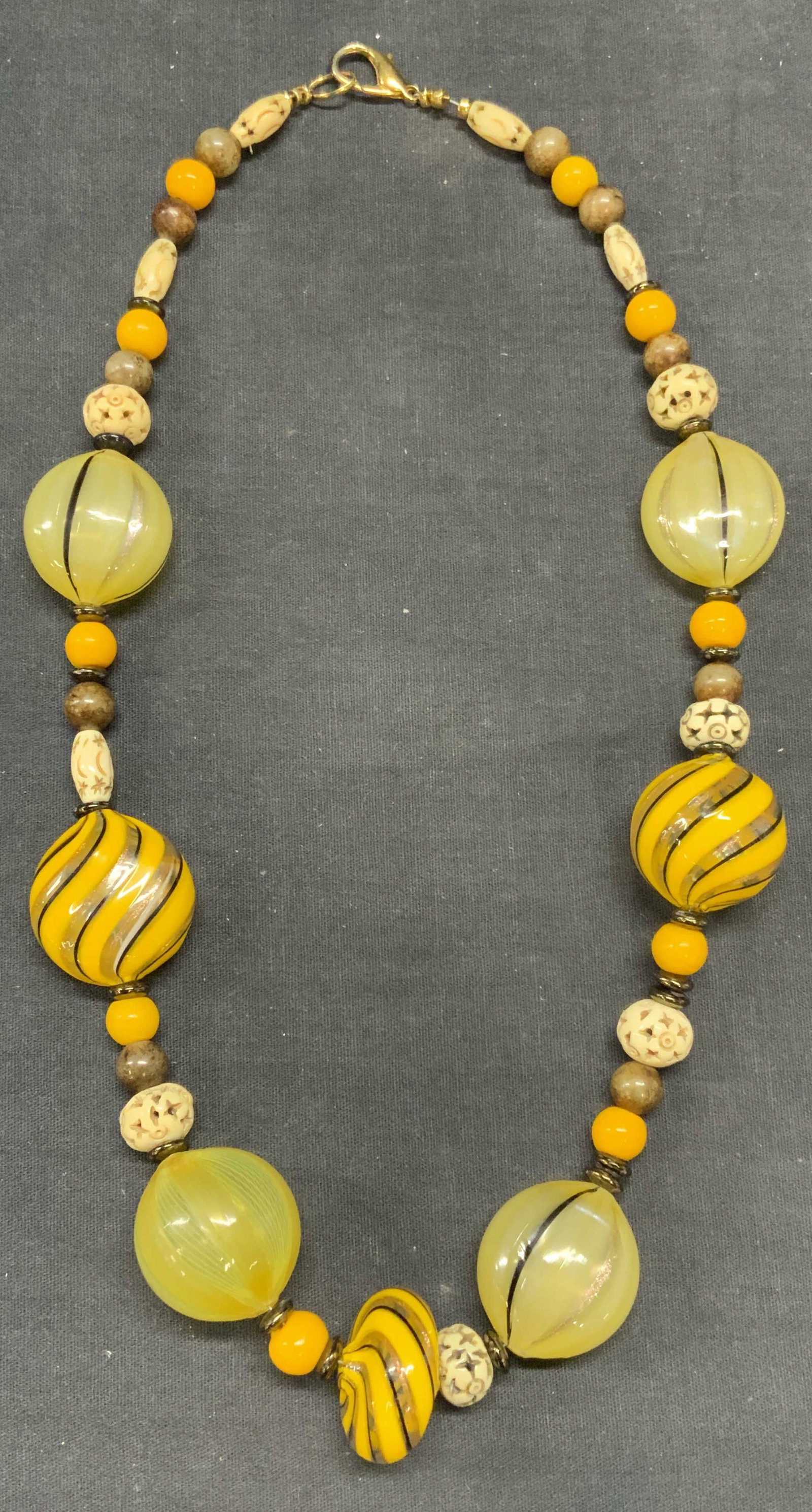 Handmade Yellow Art Glass Necklace: Handmade beaded art glass necklace with yellow, gold, and brown striped beads. Drop length approx. 10.5 inches. Some surface wear including scratching observed. Estate jewelry, costume jewelry, fashio