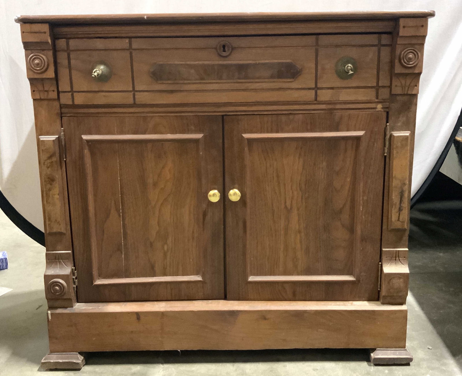Vintage Carved Wooden Cabinet W Drawer: Cabinet is vintage and wooden. Piece is brown toned. Piece has double cabinet door & 1 drawer. Drawer has hand dovetailing. Cabinet has gilt metal knob style handles. Interior has 1 wooden shelf. Cabi
