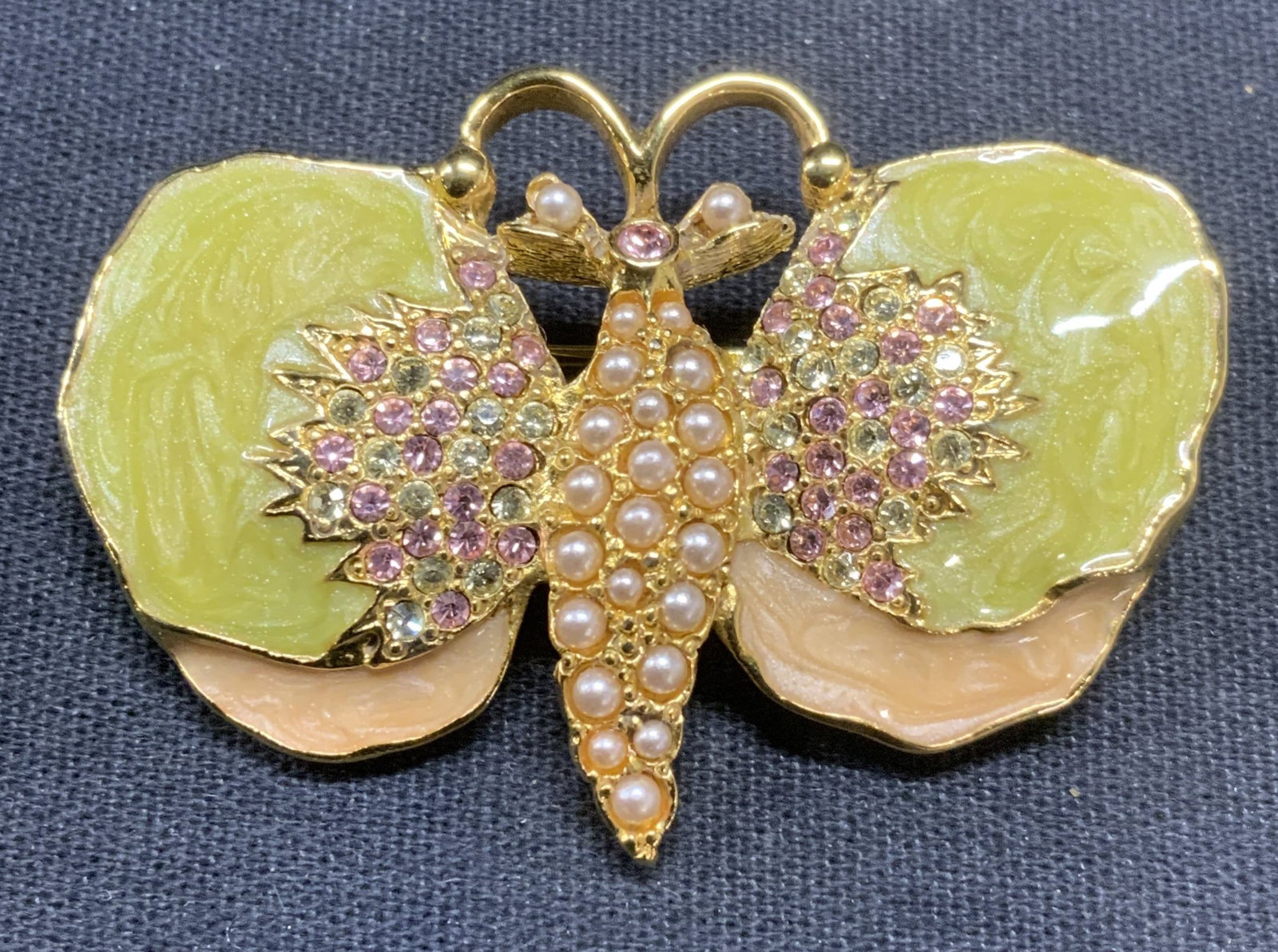 Jay STRONGWATER Gold Tn Crystal Butterfly Brooch: Jay STRONGWATER gold tone butterfly brooch. Orange and green enamel with crystal and faux pearl decoration. Signed to underside. Hinge pin to underside. Measures approx. 1.5 x 2 inches. Some surface w