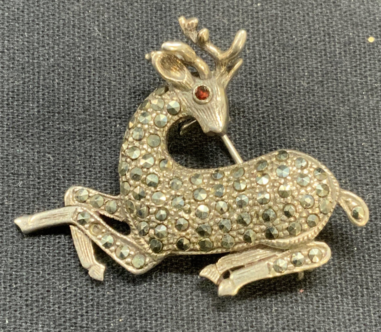 Sterling Silver Marcasite Red Crystal Deer Brooch: Sterling silver, marcasite, and red crystal deer brooch. Marked 925. Hinge pin to underside. Measures approx. 1.25 x 1.75 inches. Total weight 8.6 grams. Some scratching observed. Some marcasite may n