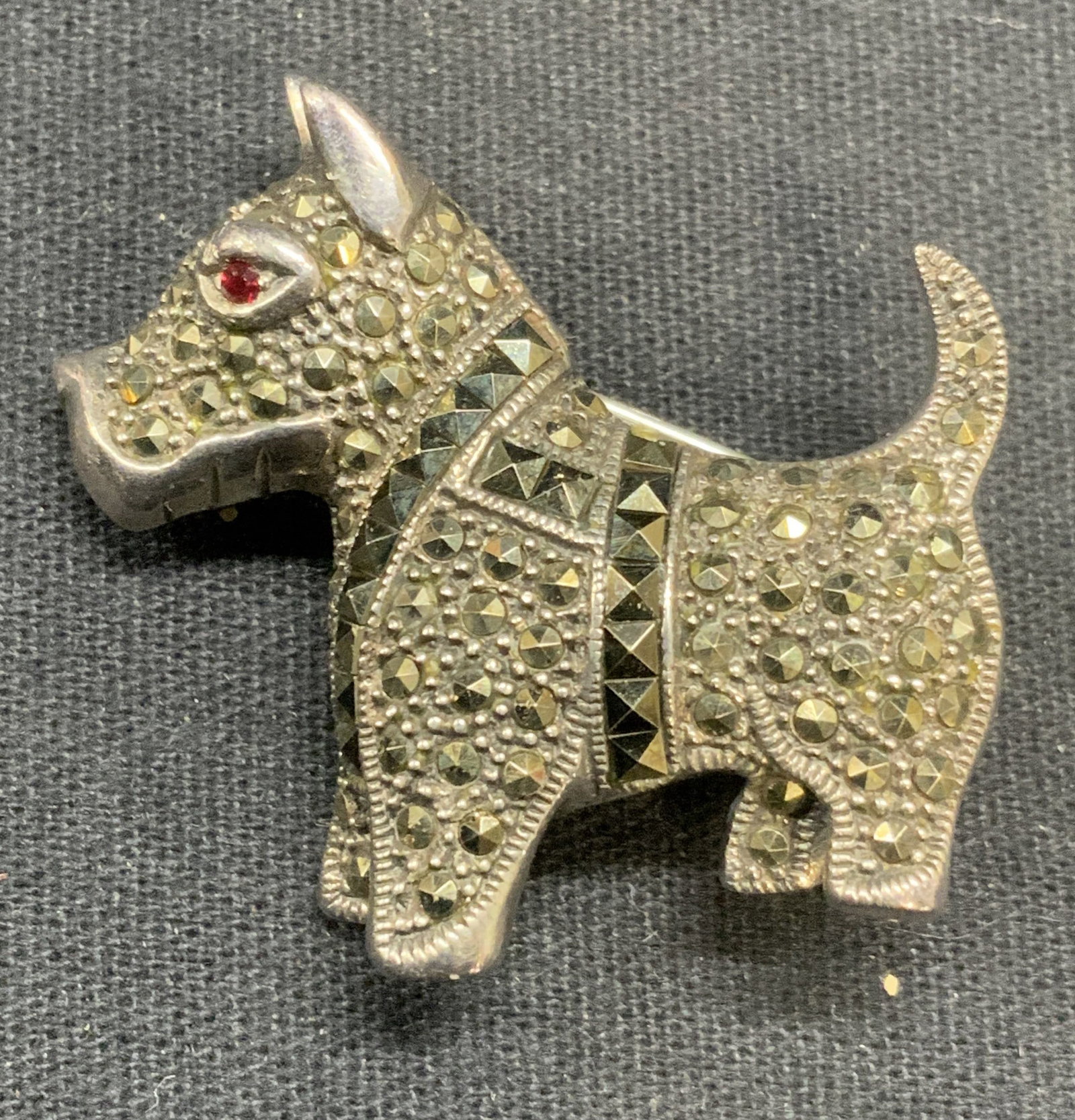 Sterling Silver Marcasite Red Crystal Dog Brooch: Sterling silver, marcasite and red crystal decorated dog brooch, marked 925. Hinge pin to underside. Measures approx. 1.25 x 1 3/8 inches. Total weight 12.6 grams. Some scratching observed. Estate jew