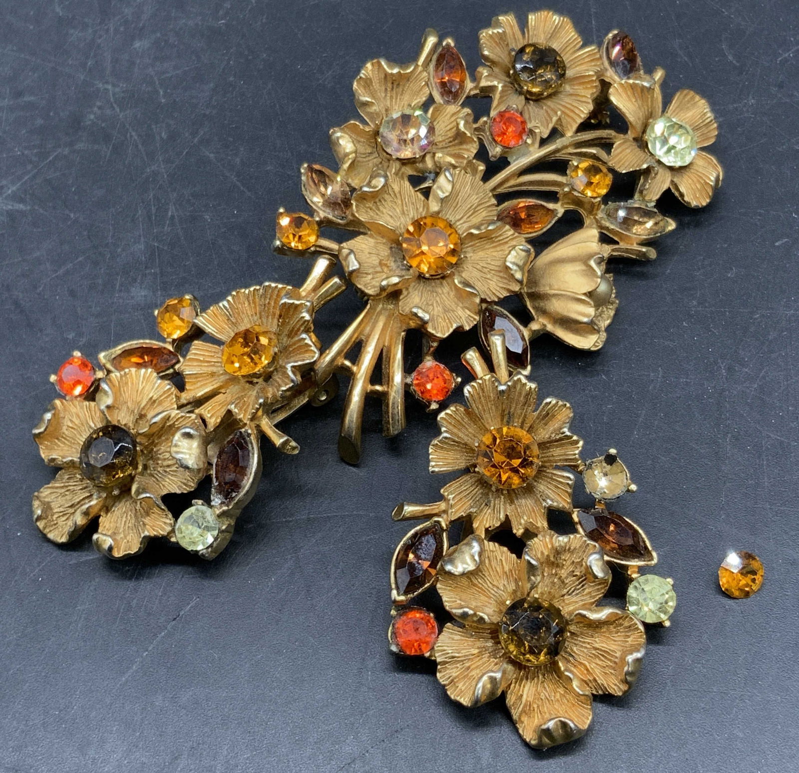 CORO Vintage Crystal Floral Earring & Brooch Set: A vintage gold tone metal flower form earring and brooch set. Pieces are decorated with faceted circular and navette form crystals & a faux pearl bead. Brooch measures approx. 2.5L x 1.5W in. Brooch p