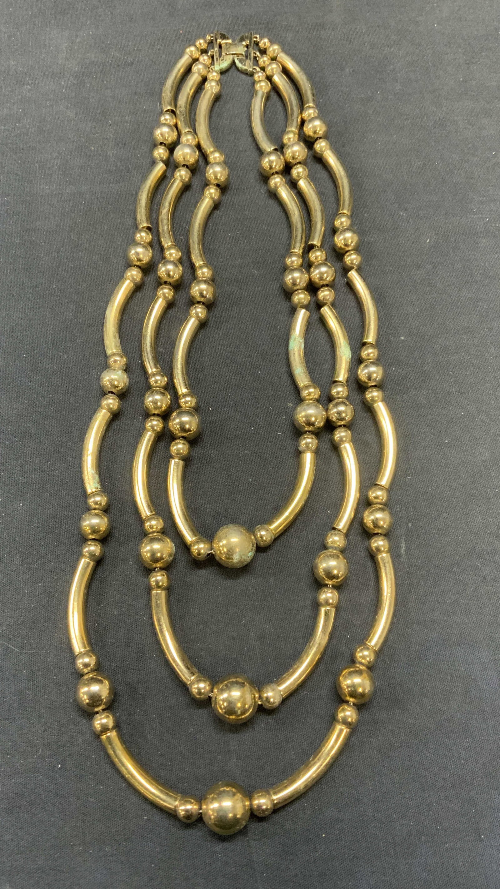 Vintage Monet Gold Tone Multi Strand Necklace: Vintage Monet gold tone beaded multi strand necklace. Signed on clasp. Drop length of shortest strand approx. 8.5 inches. Some scratching observed. Estate jewelry, costume jewelry, cocktail jewelry, f
