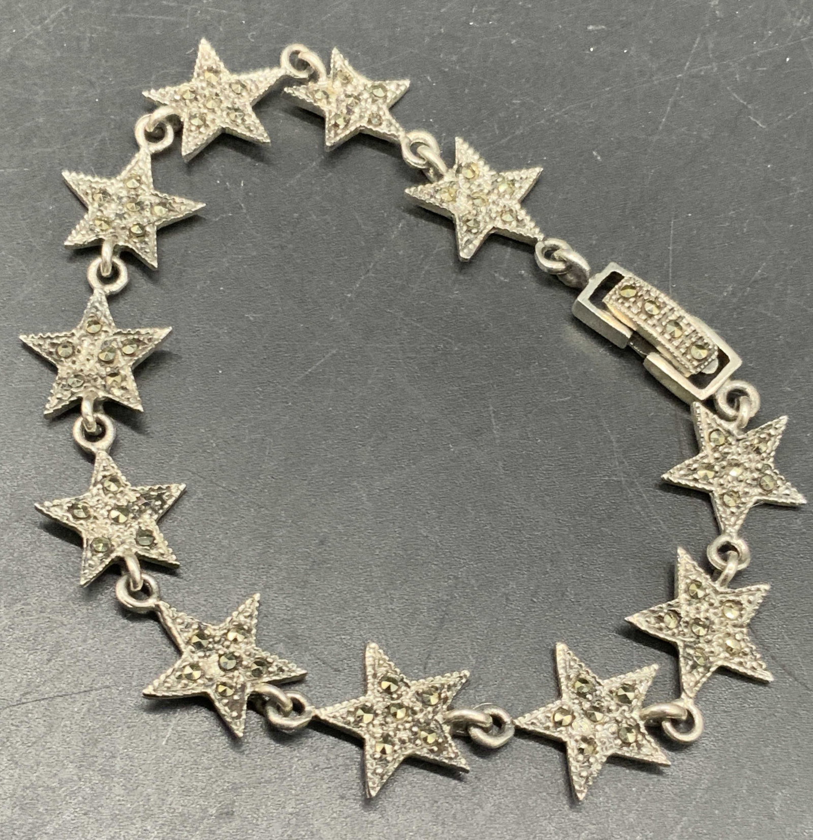 Vntg Sterling Silver Marcasite Star Motif Bracelet: A vintage sterling silver star motif bracelet studded with marcasite. Box clasp closure. Marked 925 on reverse. Bracelet length measures approx. 7.5 inches. Total weight .31 ozt. Some surface wear pre