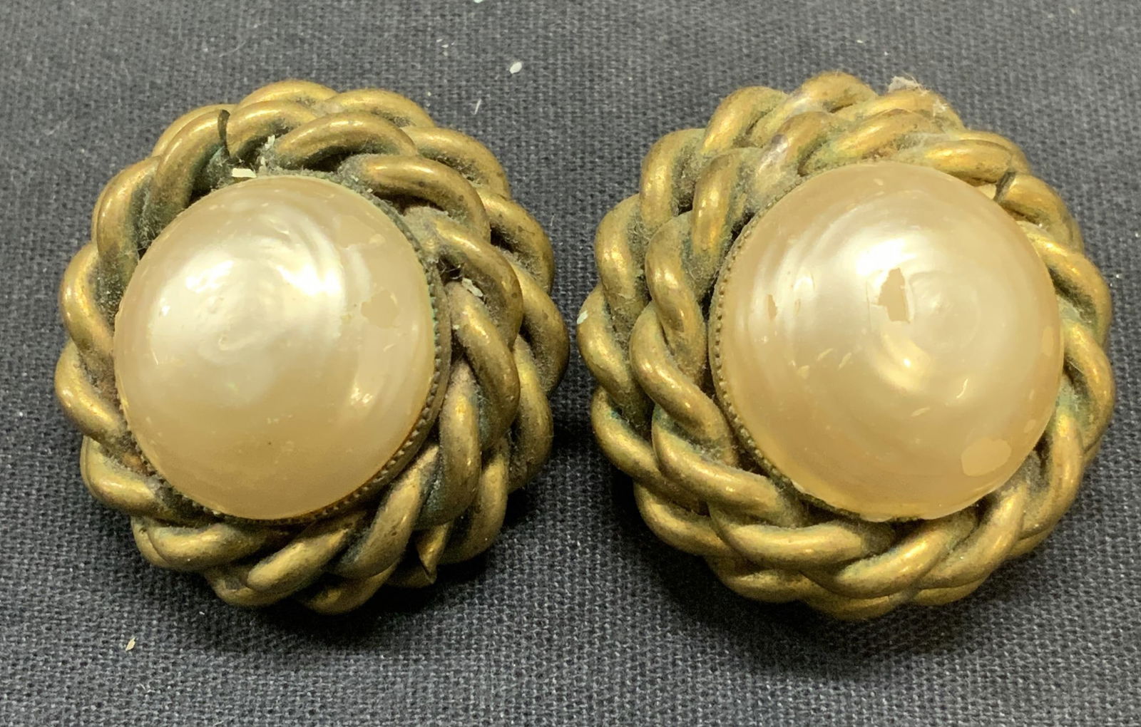 Vtg Butler & Wilson Gold Tn Faux Pearl Earrings: Vintage Butler and Wilson gold tone twisted cable border and black crystal clip on earrings. Signed to underside. Measures approx. 1.25 inches diameter. Some scratching observed. Estate jewelry, costu
