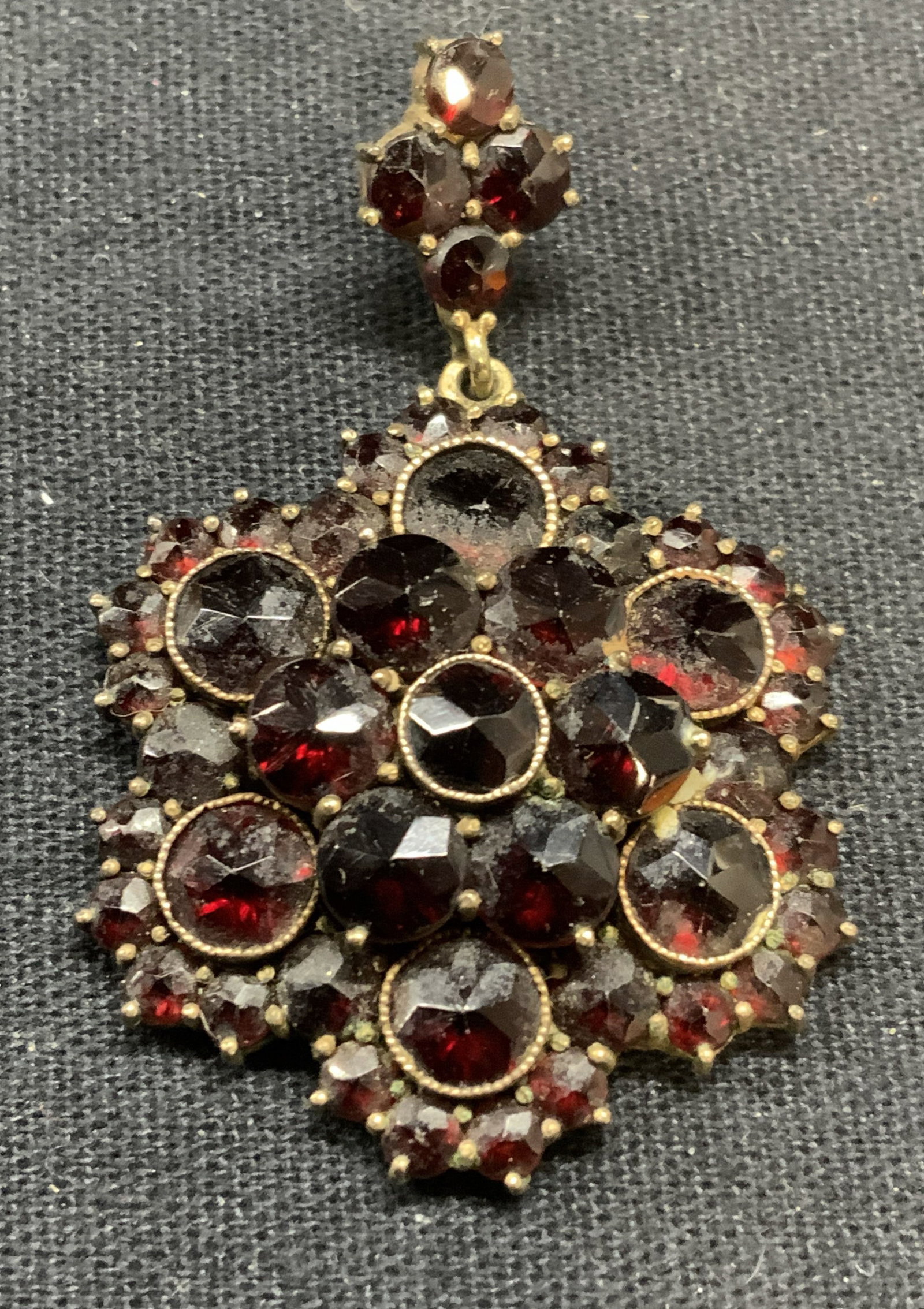 Signed Gold Tone Garnet Pendant: Signed gold tone and garnet gemstone pendant. Signed illegibly to underside, marked Germany. Measures approx. 1.75 x 1.25 inches. Some scratching observed. Estate jewelry, fine jewelry, cocktail jewel