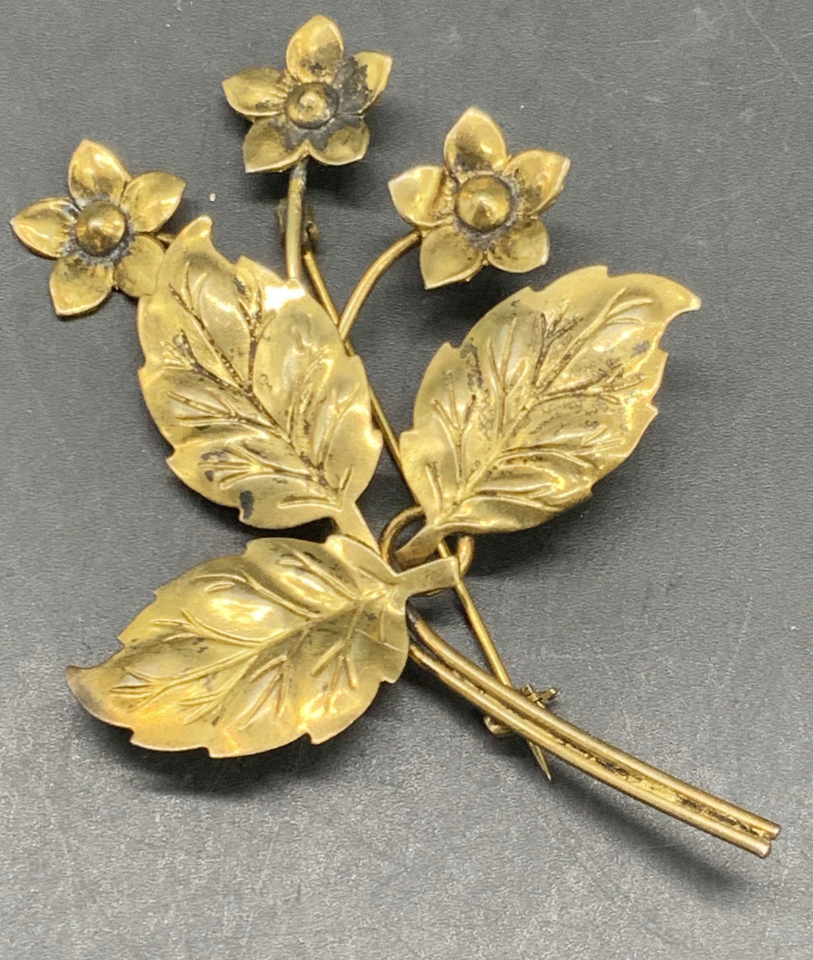 STERLING BY CORO Vermeil Floral Form Brooch: A sterling silver floral form brooch with a vermeil finish. Reverse possesses metal pin closure and is marked STERLING BY CORO. Measures approx. 3L x 2.25W in. Total weight .21 ozt. Some surface wear
