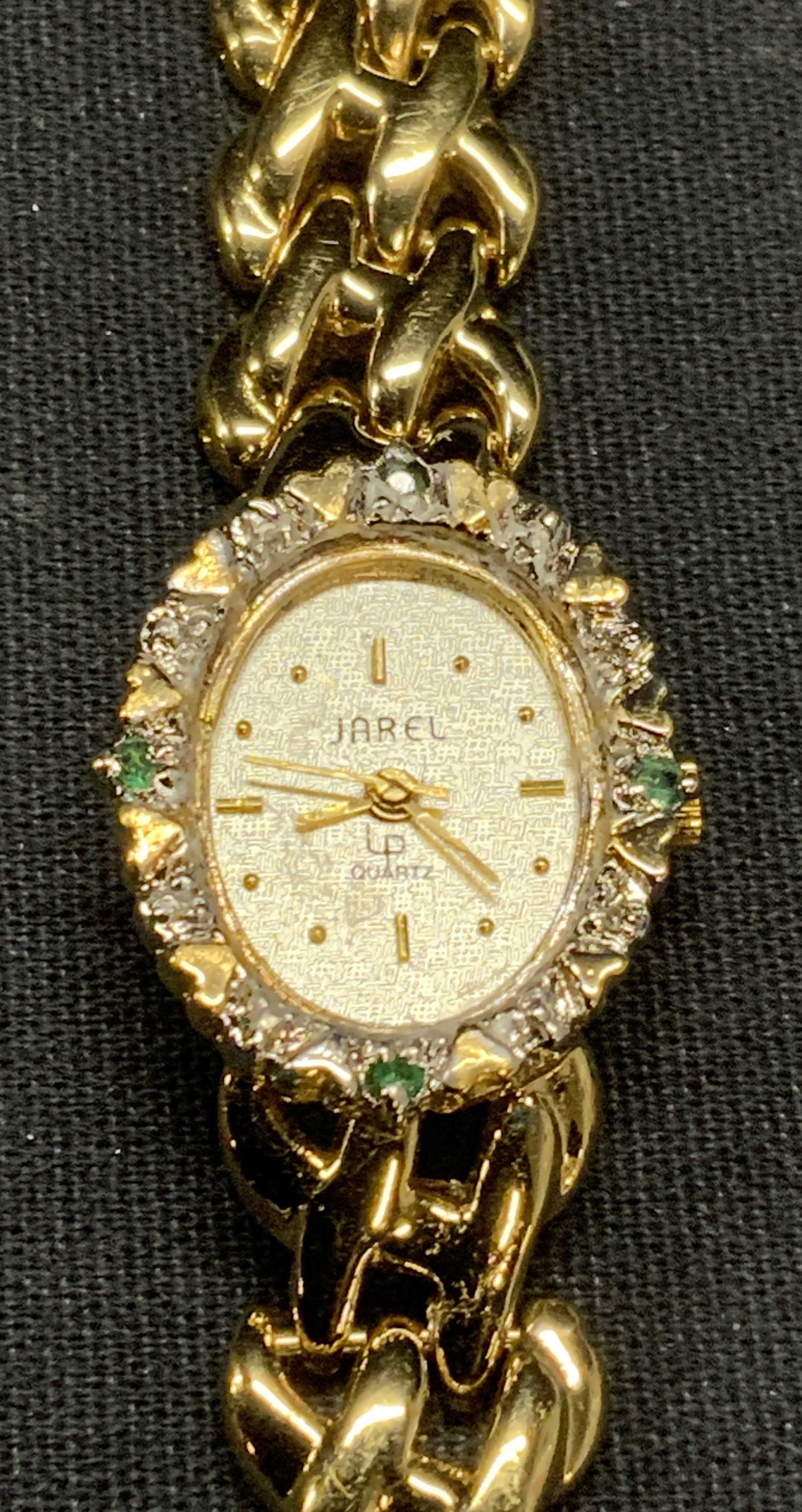 Vintage Jarel Gold Tone Crystal Watch: Vintage Jarel gold tone chain strap watch with colorless and green crystal decorated face. Signed on face. Stainless steel back and base metal bezel. Measures approx. 7 inches long. Face measures appr