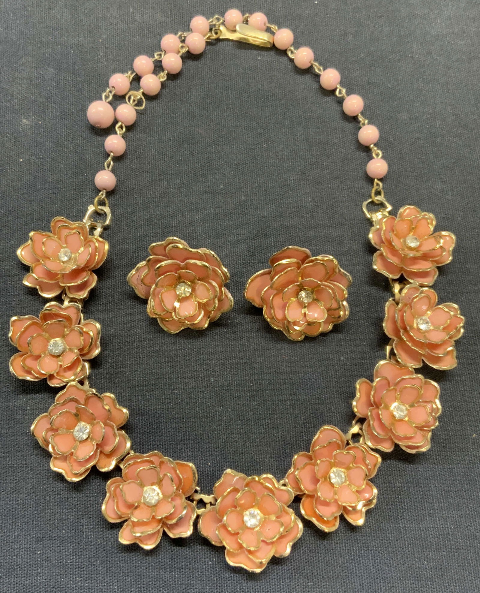 2 Vtg Coro Pink Flower Earrings & Necklace Set: Lot of 2 vintage matching Coro gold tone colorless crystal and pink sculptural flower clip on earrings and beaded necklace. Signed on earrings. Necklace unsigned. Earrings measure approx. 1 inch wide.