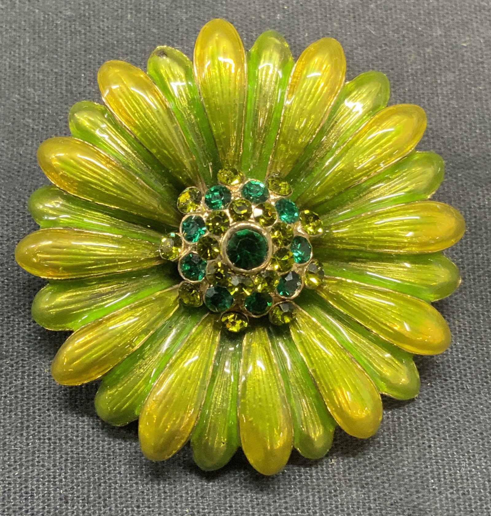 Vintage Monet Green Crystal Flower Brooch: Vintage Monet green enamel and green toned crystal flower brooch. Signed to underside. Hinge pin to underside. Measures approx. 2 inches diameter. Some scratching observed. Estate jewelry, costume jew