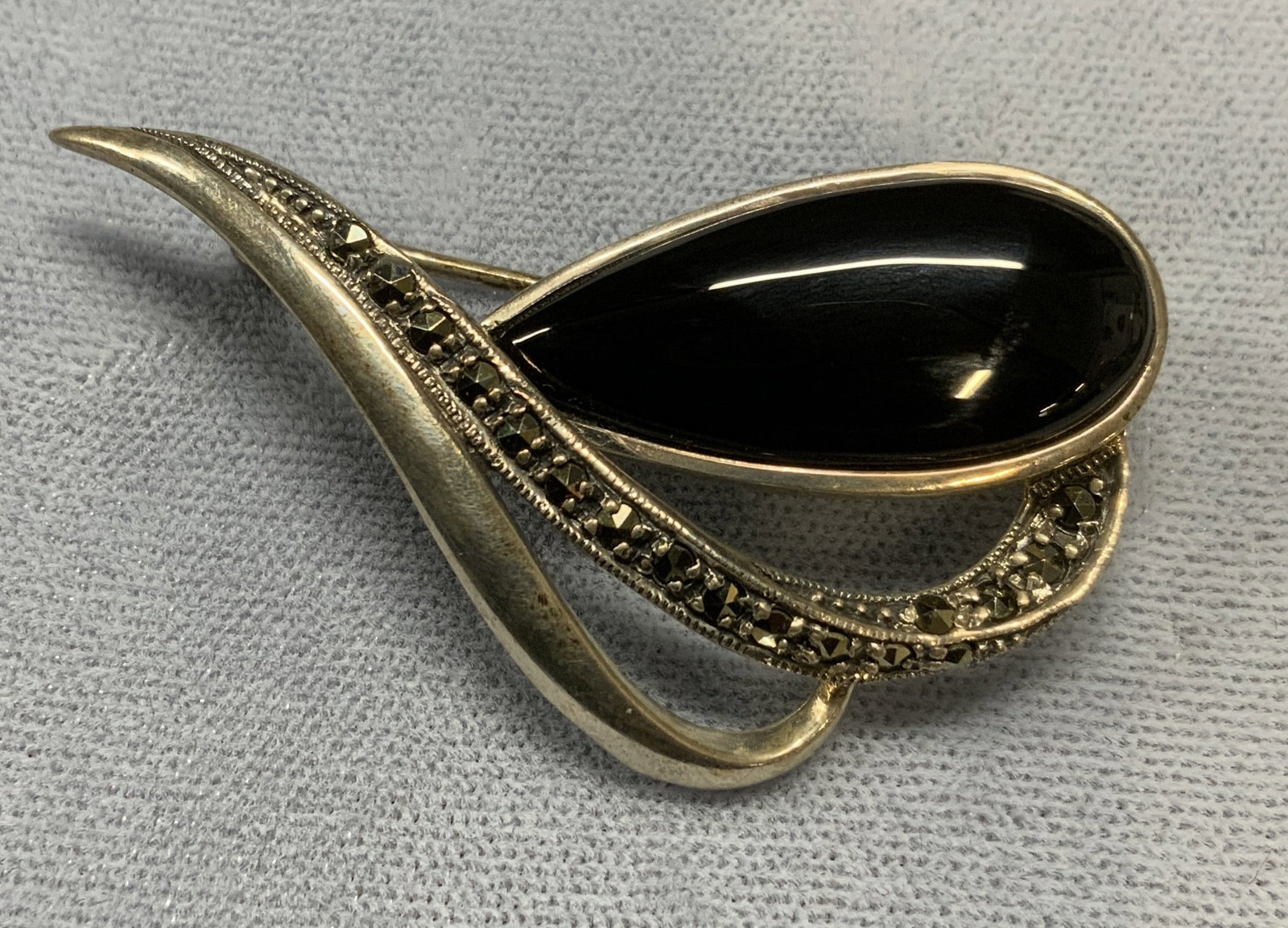 Signed Vintage Sterling Silver Black Stone Brooch: Signed Vintage sterling silver brooch with black stone and marcasite decoration. Marked Vintage, sterling. Hinge pin to underside. Measures approx. 1 x 2 inches. Total weight 10.9 grams. Some surface 