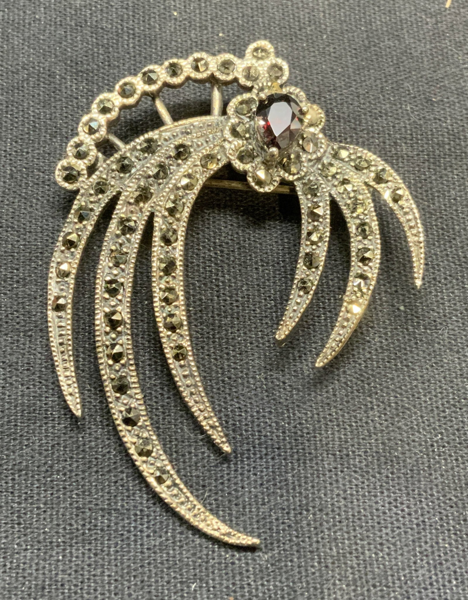 Sterling Silver Marcasite Red Stone Brooch: Sterling silver brooch with marcasite and red glass stone. Marked 925. Hinge pin to underside. Measures approx. 2 x 1.5 inches. Total weight 10.6 grams. Some surface wear including scratching observed