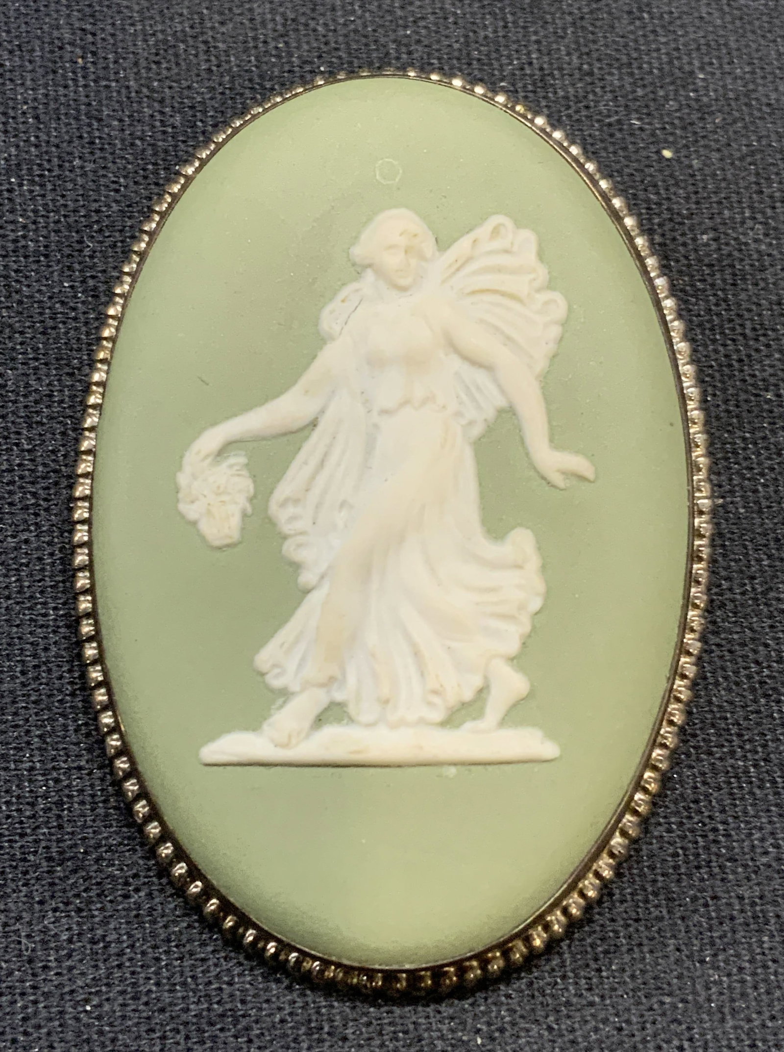Wedgwood Sterling Silver Jasperware Brooch: Vintage Wedgwood green Jasperware brooch with white Greco Roman style figural bas relief. Sterling silver frame tests for sterling using puritest kit. Signed to underside. Made in England. Hinge pin t