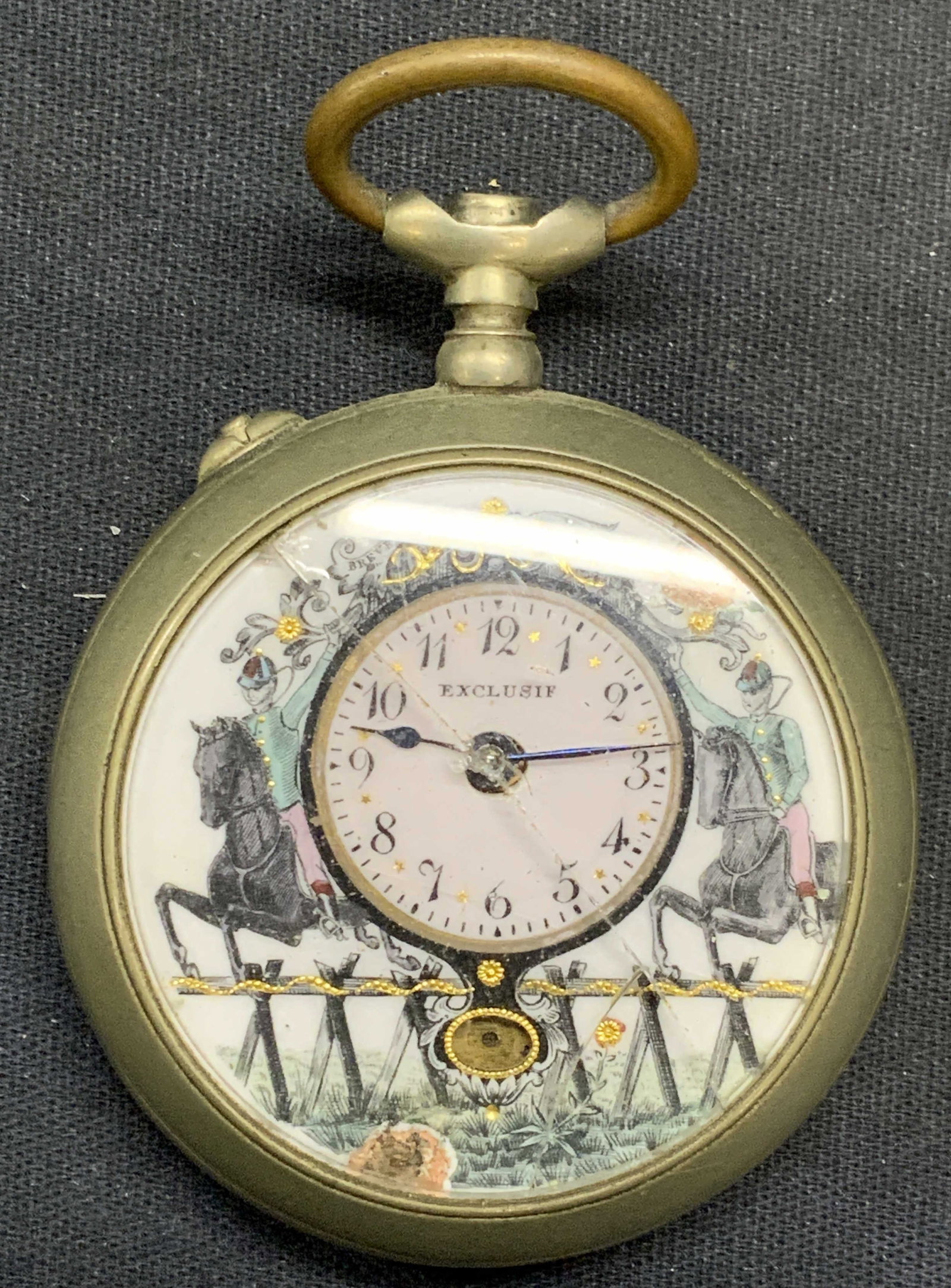 Antique Exclusif Silver Tone Horse Pocket Watch: Antique silver tone pocket watch marked Exclusif on watch face. Horse and jockey motif hand painted on porcelain face. Measures approx. 2 inches diameter. Interior mechanism needs repair/replacement. 