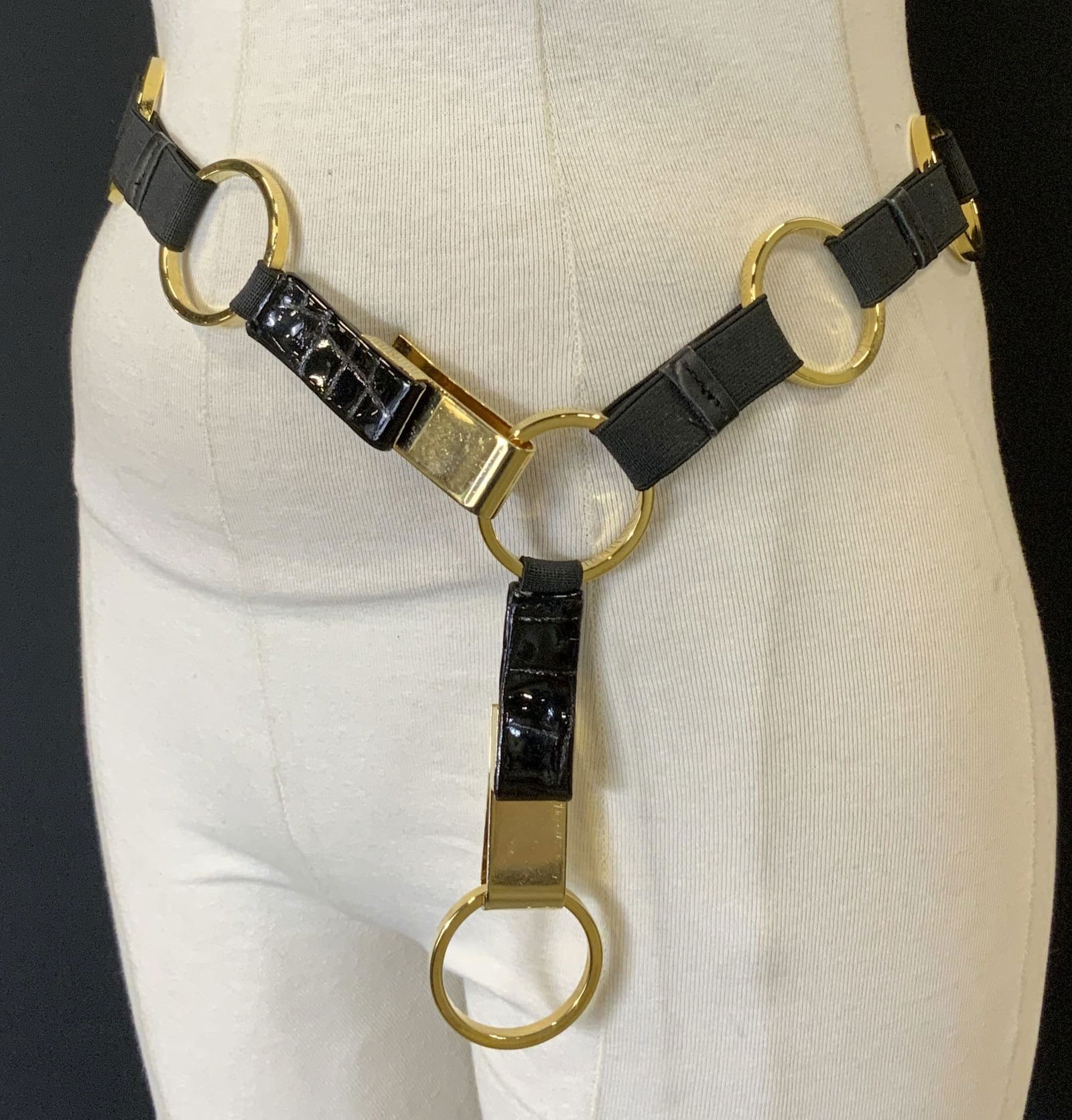 MOSCHINO Style Gold Tone Circle Stretch Belt: Heavy gold tone open circle belt connected with a black stretch elastic band. Circles measure 1.5 in. Hook and loop clasp , which can be hooked on another circle to be made for smaller waists., 36/37
