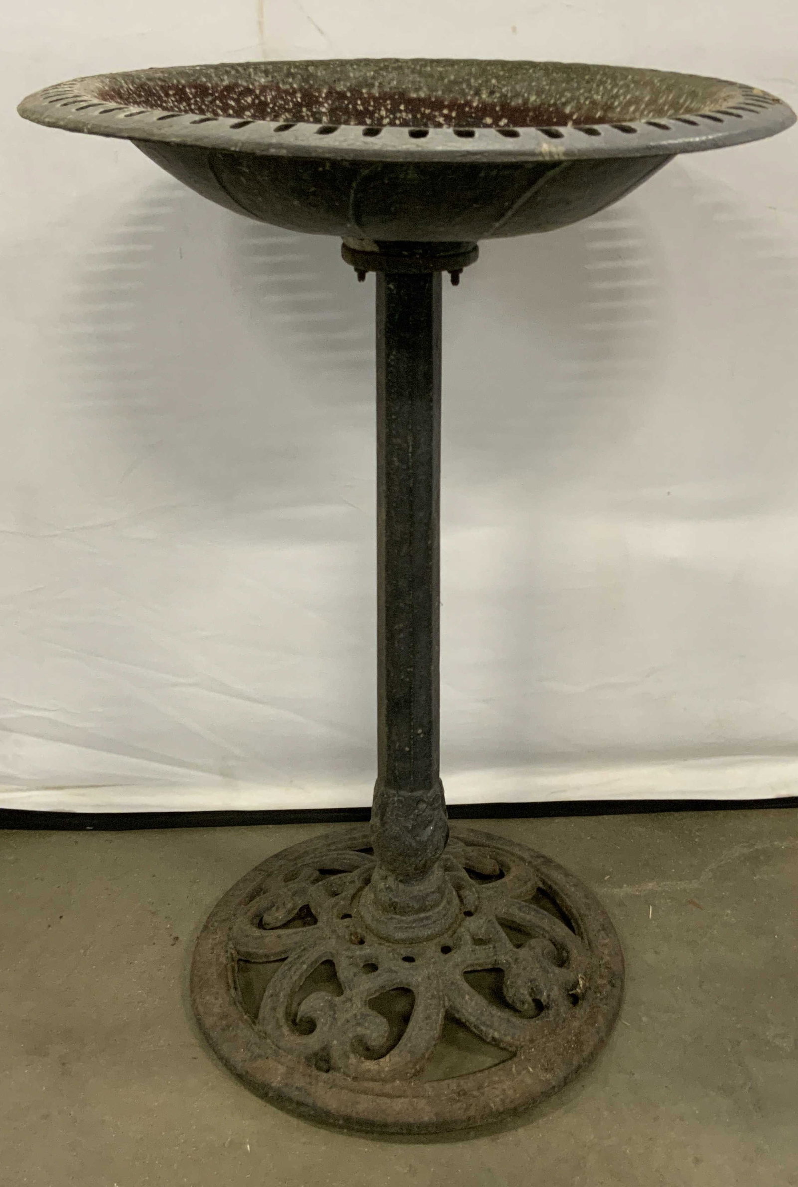 Vintage Black Iron Base Birdbath: Vintage iron base birdbath with a pierced metal top. Primarily black hued. Measures approx. 29H x 19.75W in. Some surface wear consistent with age, use, and exposure. Some losses to finish and discolo