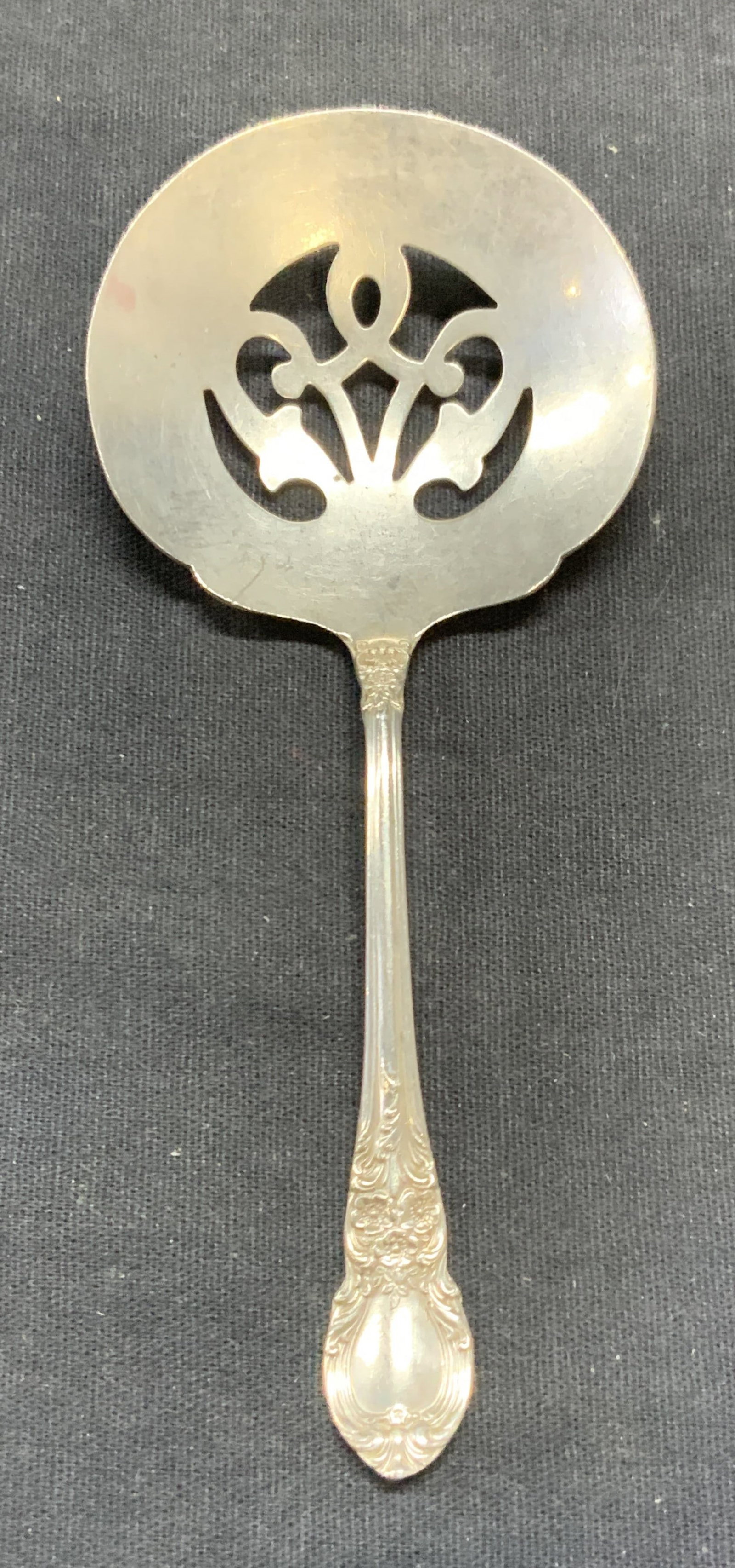 Vintage Lunt Sterling Silver Bon Bon Spoon: Vintage Lunt sterling silver Bon Bon spoon. Raised scroll motif on handle and pierced spoon detail. Trademarked to underside. Marked sterling. Measures approx. 5 inches long. Total weight .75 ozt. Som