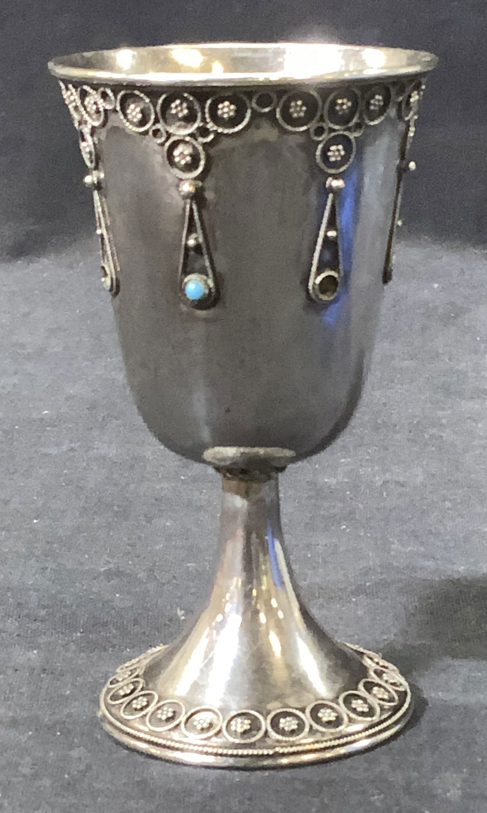Sterling Silver Kiddish Cup, 1.66 ozt: Hand Crafted Sterling silver Kiddish Cup/ goblet. 1.66 ozt. Raised reticulated design . Stamped on underside, illegible. Lacking a few turquoise glass stones. Measures 4.5 x 2.25 in. W Sterling silver