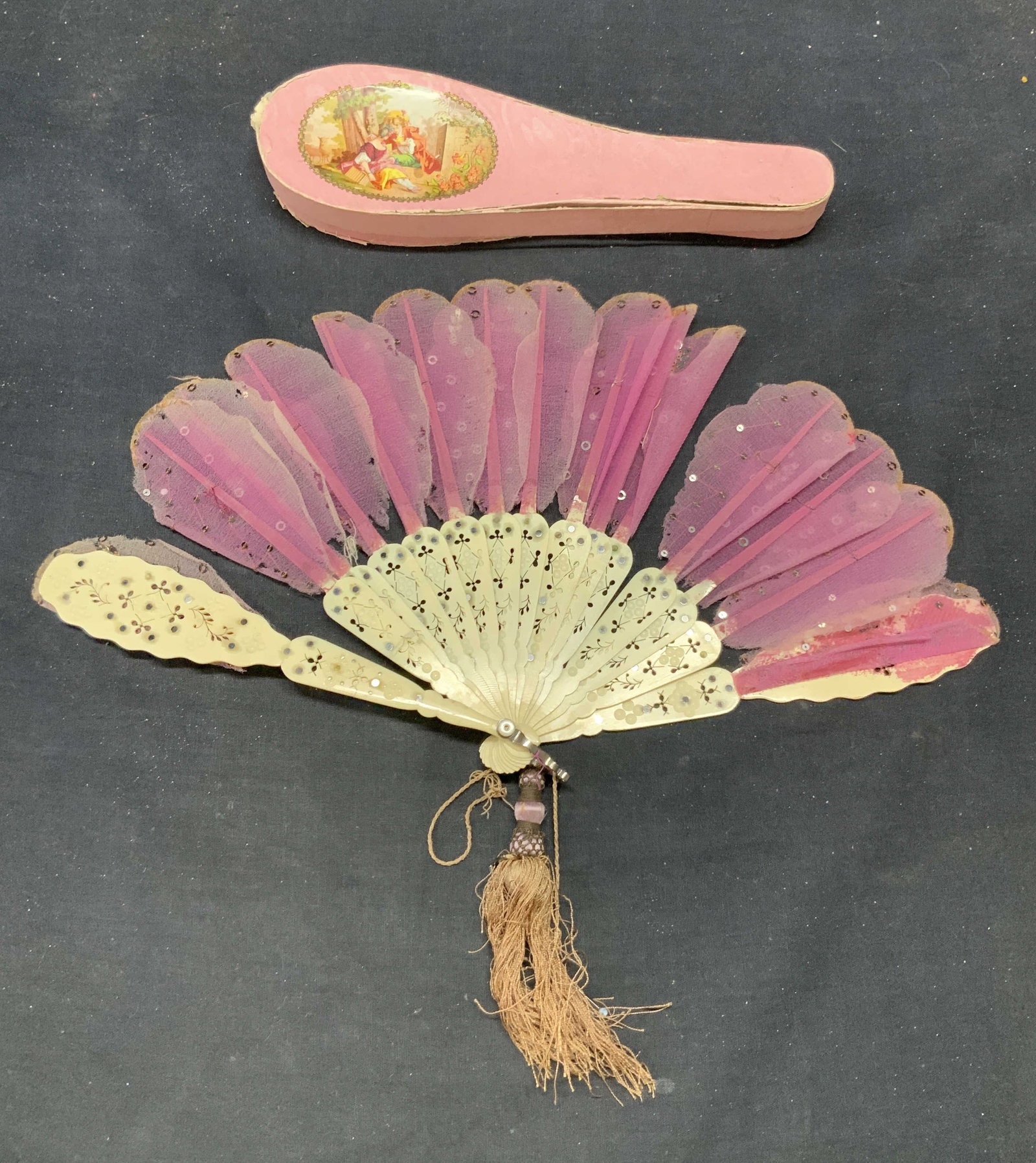 Antique Purple Silk & Bone Sequin Fan: Antique silk and bone fan. Purple silk with sequin decoration. Pierced bone frame and tassel detail. Includes decorative fan box. Measures approx. 8.5 x 15 inches. Tassel not attached. Wear to fabric 