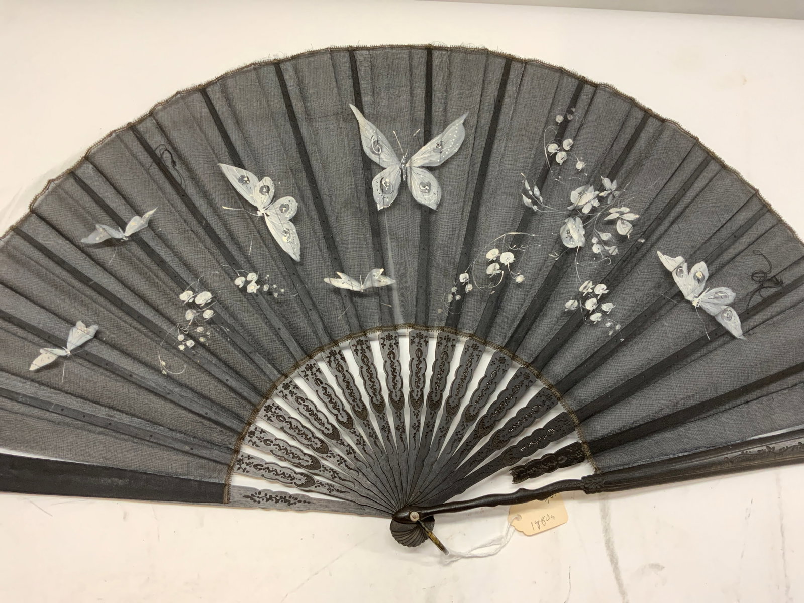 Antq Hand Painted Gauze & Wood Butterfly Fan: All black hand painted gauze fan with white butterflies. Bamboo frame , carved with Victorian patterns, c.,1880s. 1 stick partially missing. Fan length is 13.75 in. Long. 26 in. wide when open. Luxury
