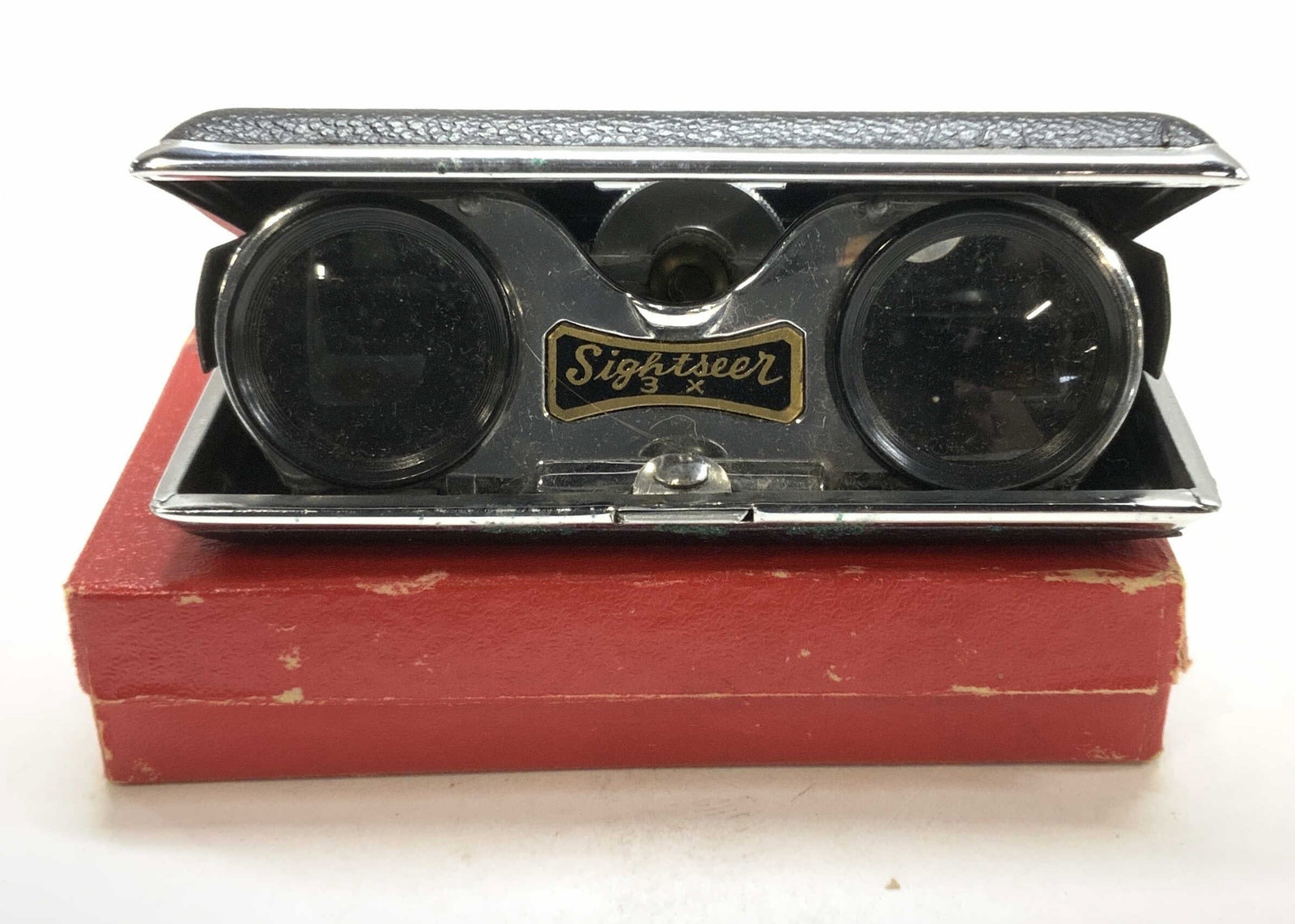 Vintage Sightseer Collapsible Binoculars, Japan: 3x magnification binoculars., collapsible binoculars , metal with black faux leather texture., measures 4.25 in. Long x 2.75 in. Wide when flat. Push button open to expand. 1.5 in. Ht when open. Comes