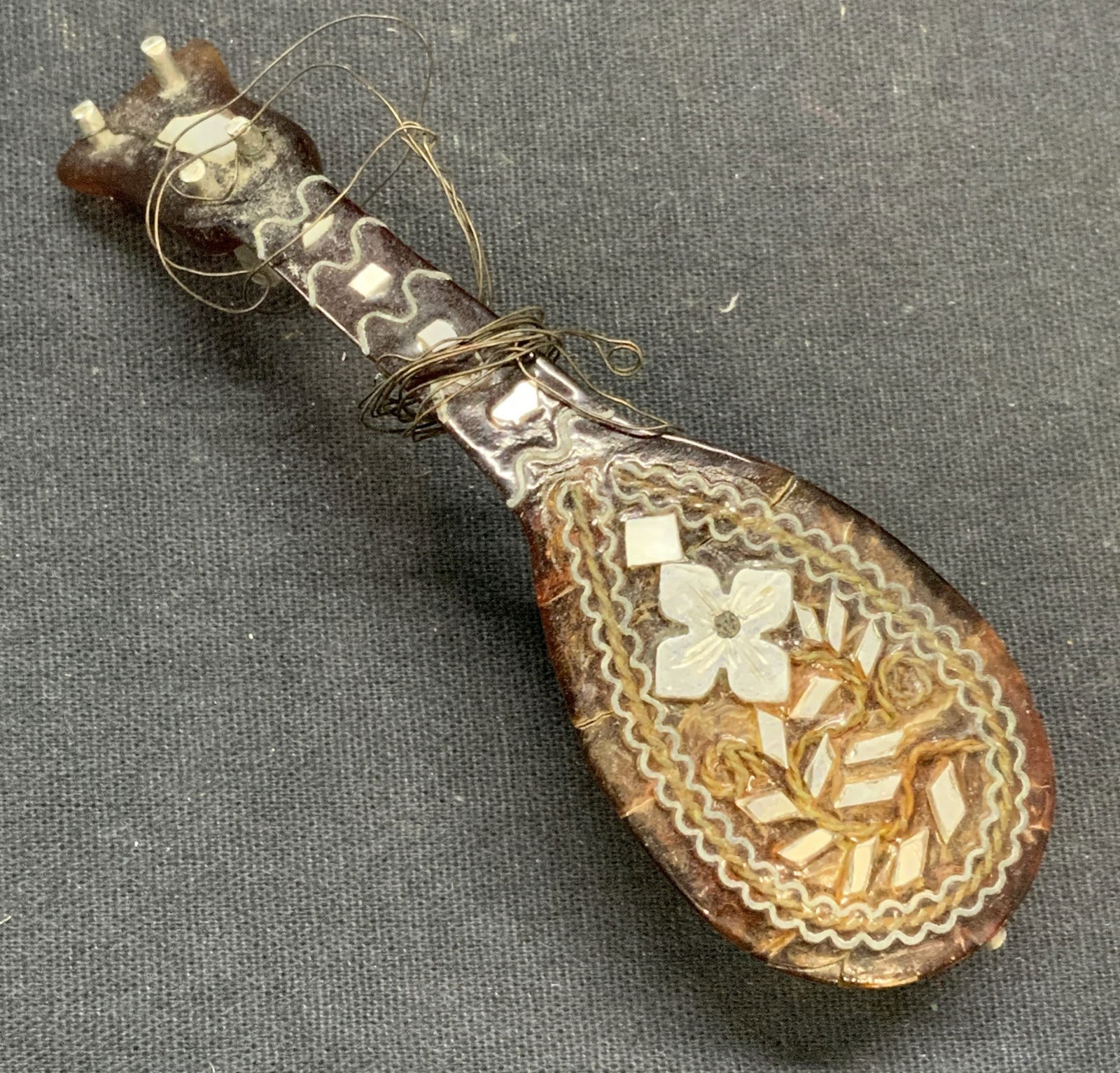 Vintage Inlaid Mother of Pearl Mandolin Figural: Vintage mandolin figural with inlaid mother of pearl and silver tone metal. Composed of acrylic. Measures approx. 3.25 inches long. Surface wear including scratching and cracking observed. Mandolin, m