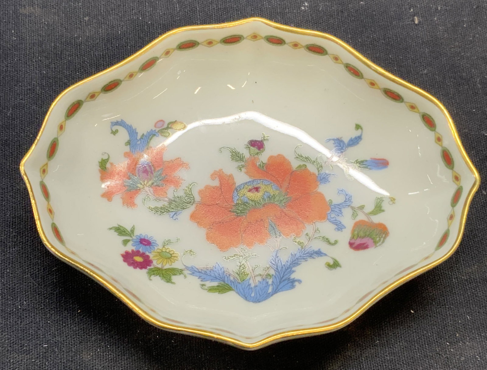 Raynaud Limoges Porcelain Floral Dish, France: Raynard Limoges porcelain dish. Hand painted floral motif with gilt decoration. Trademarked to underside. Made in France. Measures approx. 4.25 x 3.25 inches. Some surface wear including scratching ob
