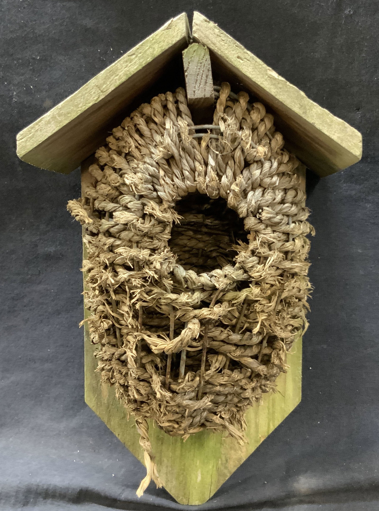 Wood & Seed Grass Woven Birds Nest: Crafted birds next made with wooden backing and oven seed grass for the actual nest. Approx 10 inches long 5 inches wide Seed grass weaving needs evident repairing and wood has residue from previous u