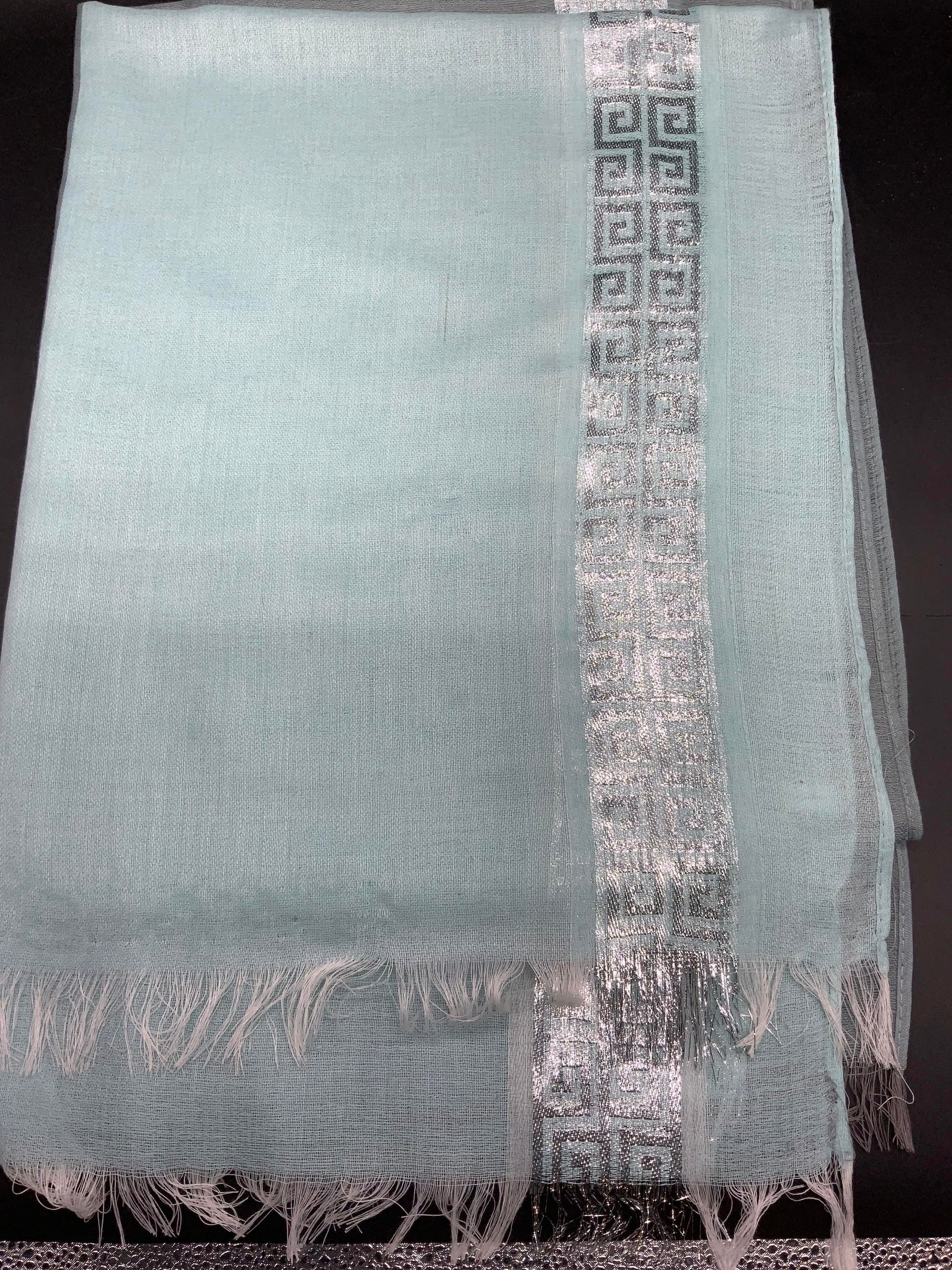 Maya Maniadi Shawl w Silver Metallic Greek Key: Aqua blue shale with silver metallic Greek key pattern along edges. Measures 27 x 70 in. Gauzy fabric. Designer label Maya Maniadi. Slight pull in fabric see picture. Shawl, wrap, scarf, accessories,
