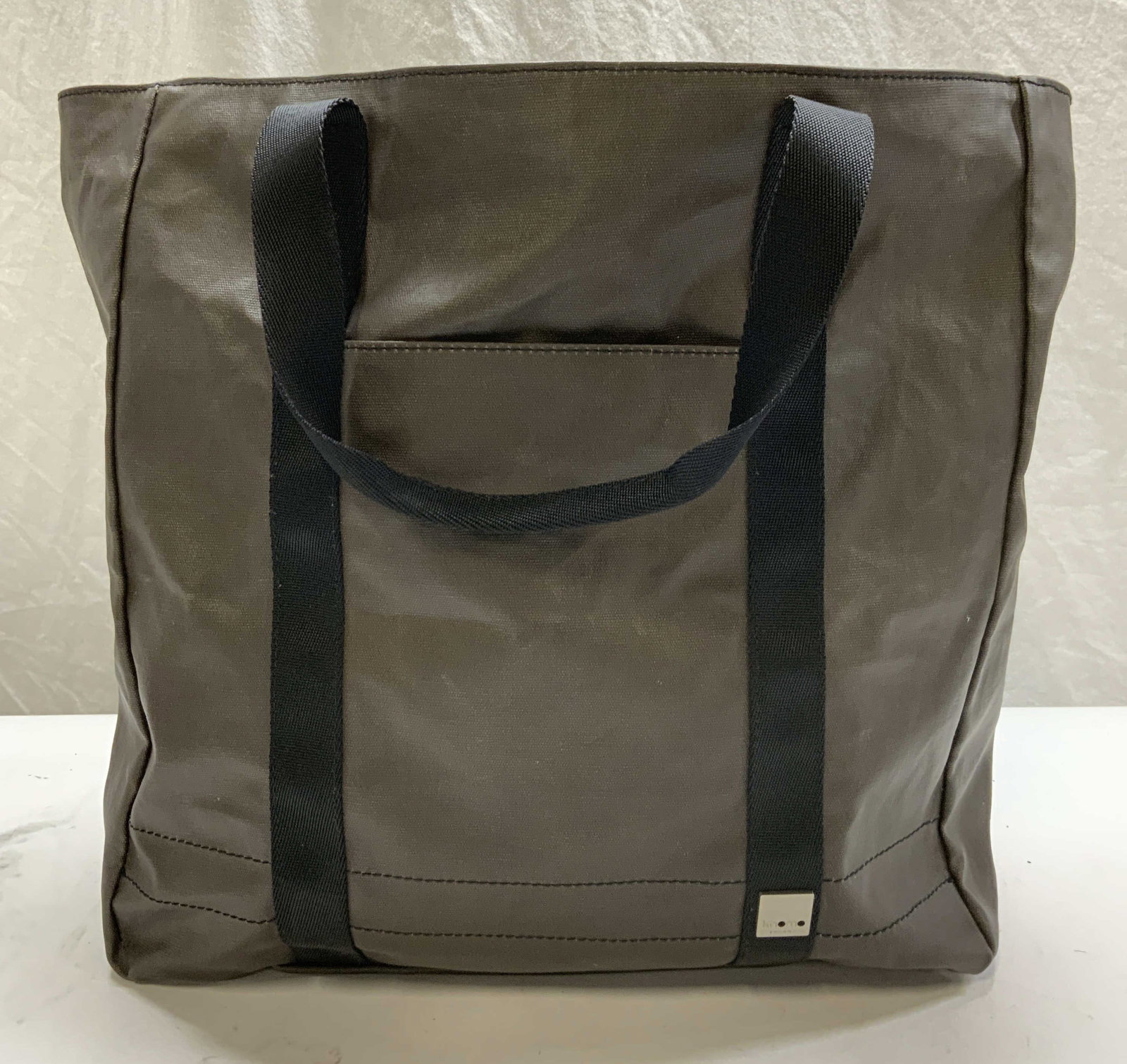 Knomo London Brown Coated Canvas Handbag: Knomo London brown coated canvas tote handbag. Signed on hardware. 1 zippered pocket to interior. Measures approx. 15 x 6 x 15 inches. Some wear to material and lining consistent with exposure. Knomo 