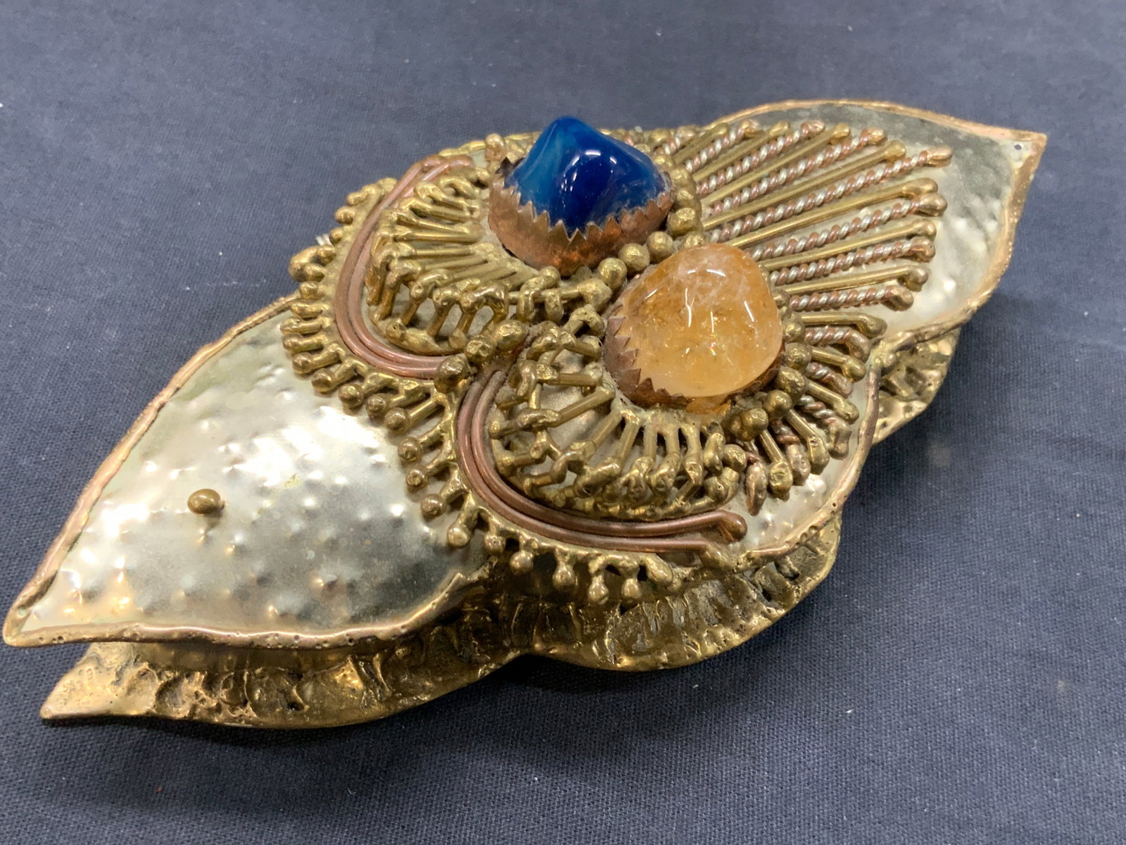 Silver & Gold Metal Made Trinket Box, Mexico: Vintage silver and gold toned metal made hinged trinket box with ornately crafted lid with blue and gold toned Quartz stones within the lid. Marked made in Mexico on underside of lid. Approx 7 inches 