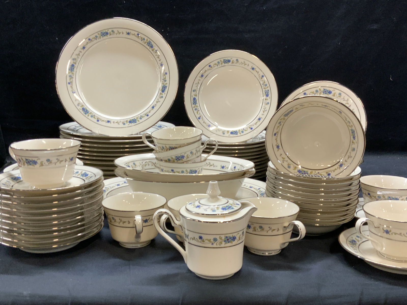 NORITAKE Silver Gilt Floral Chinaware 85: NORITAKE Chinaware # 7016 Norma Pattern. cream toned porcelain with hand painted blue flowers and green leaves with silver gilt edges. Made in Japan. Some plates have some lightly worn paint, i.e. des