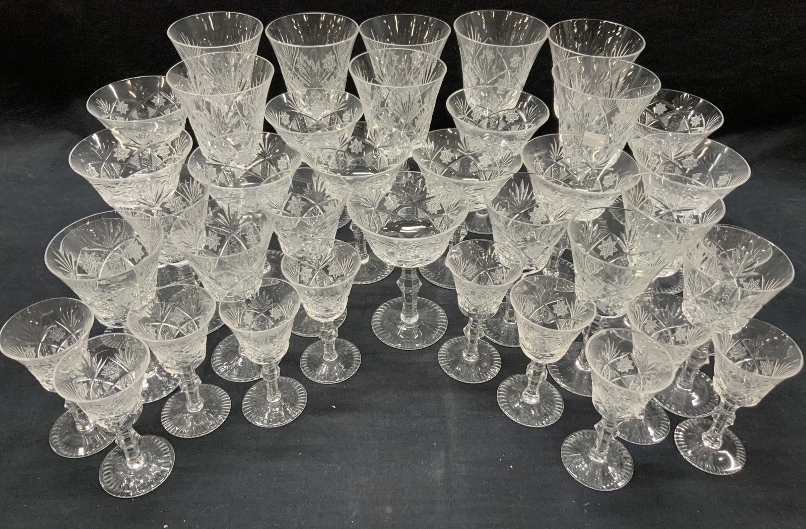 Set 39 Cut Glass Stemware: Set of 39 cut glass stemware glasses with various sizes. 12 Cordial glasses at 4.25 inches tall. 8 glasses at 5.75 inches tall. 11 glasses with wide rims, at 5.5 inches tall and 4 inch diameter. And 8